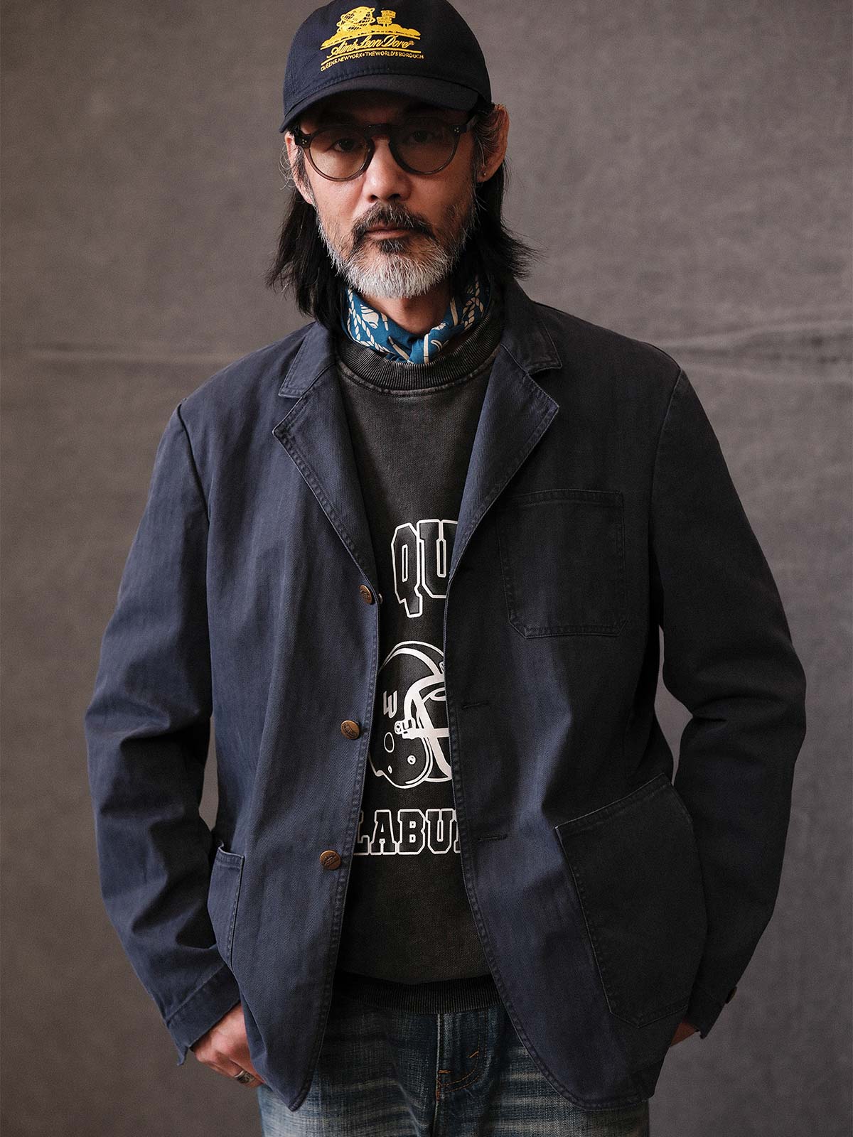 詳細画像: ウォッシュ加工されたヘリンボーン柄の生地とヴィンテージメタルボタンのディテール
モデル画像: ゆるやかなフィットでスタイリッシュなヴィンテージウォッシュジャケットの着用イメージ