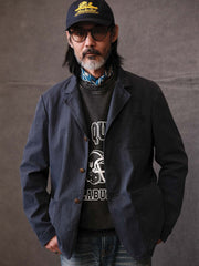 詳細画像: ウォッシュ加工されたヘリンボーン柄の生地とヴィンテージメタルボタンのディテール
モデル画像: ゆるやかなフィットでスタイリッシュなヴィンテージウォッシュジャケットの着用イメージ