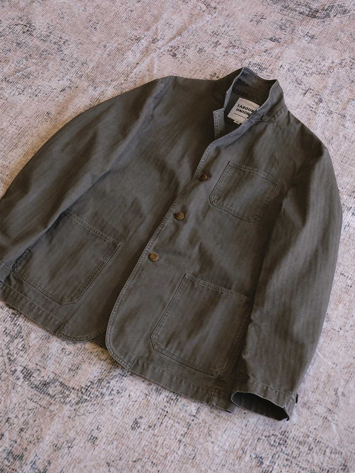 製品画像: ヴィンテージヘリンボーンウォッシュジャケットの全体画像、独特な時代感を持つデザイン
詳細画像: ウォッシュ加工されたヘリンボーン柄の生地とヴィンテージメタルボタンのディテール
