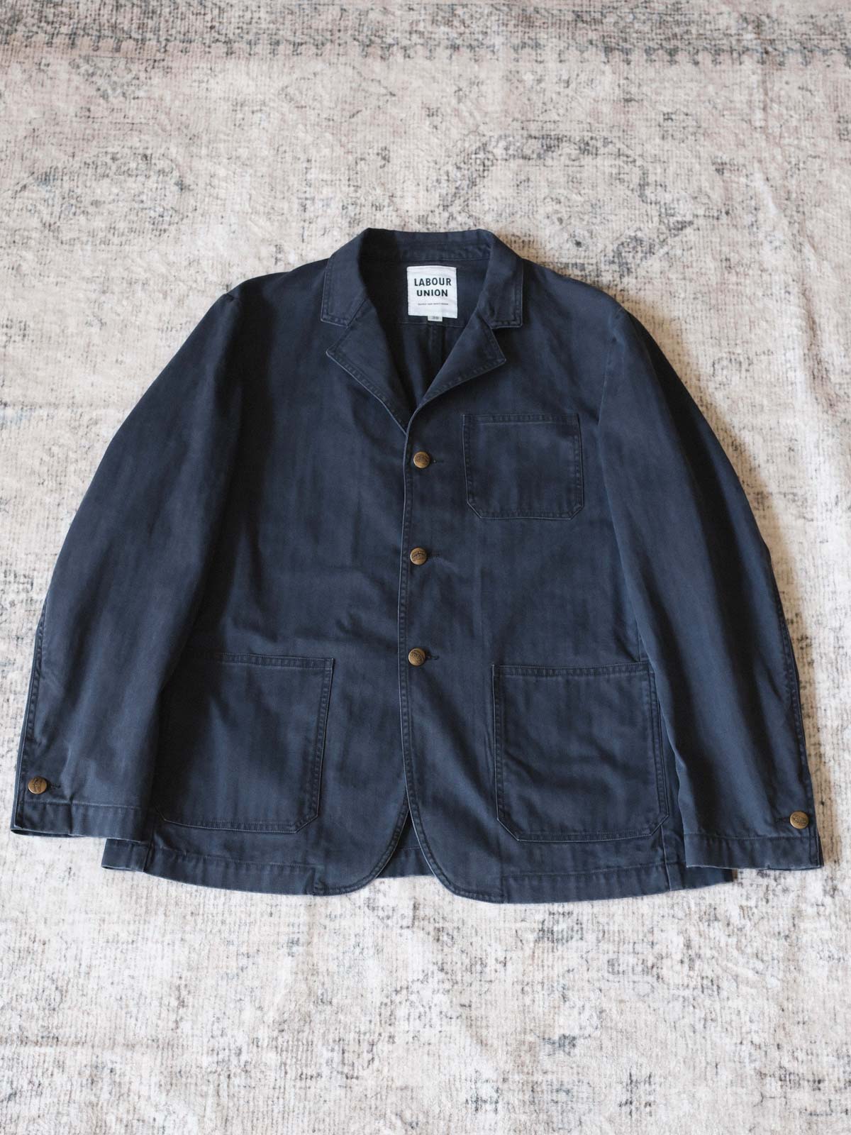 製品画像: ヴィンテージヘリンボーンウォッシュジャケットの全体画像、独特な時代感を持つデザイン
詳細画像: ウォッシュ加工されたヘリンボーン柄の生地とヴィンテージメタルボタンのディテール