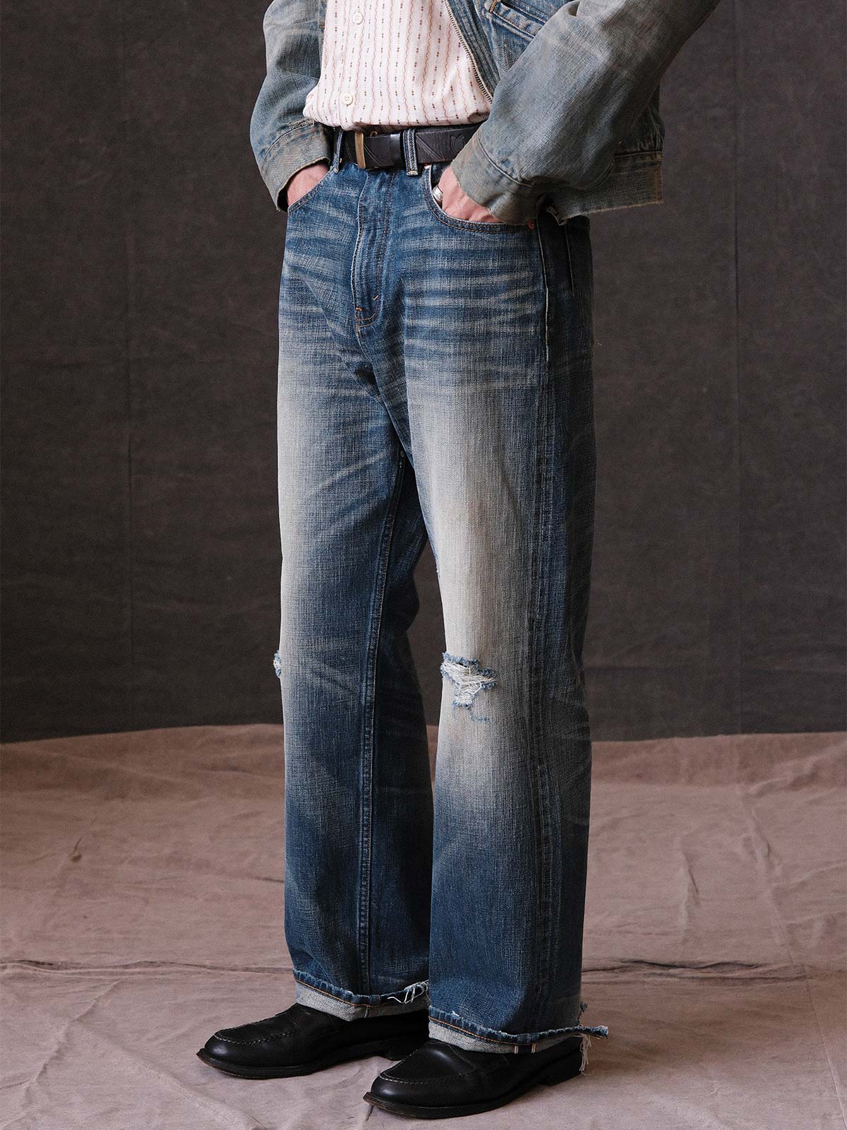 詳細画像: 手作業で施されたヴィンテージウォッシュ加工のディテールとダメージ部分
モデル画像: ゆるやかなフィット感が特徴の、手作業ヴィンテージウォッシュ加工ダメージデニムの着用イメージ