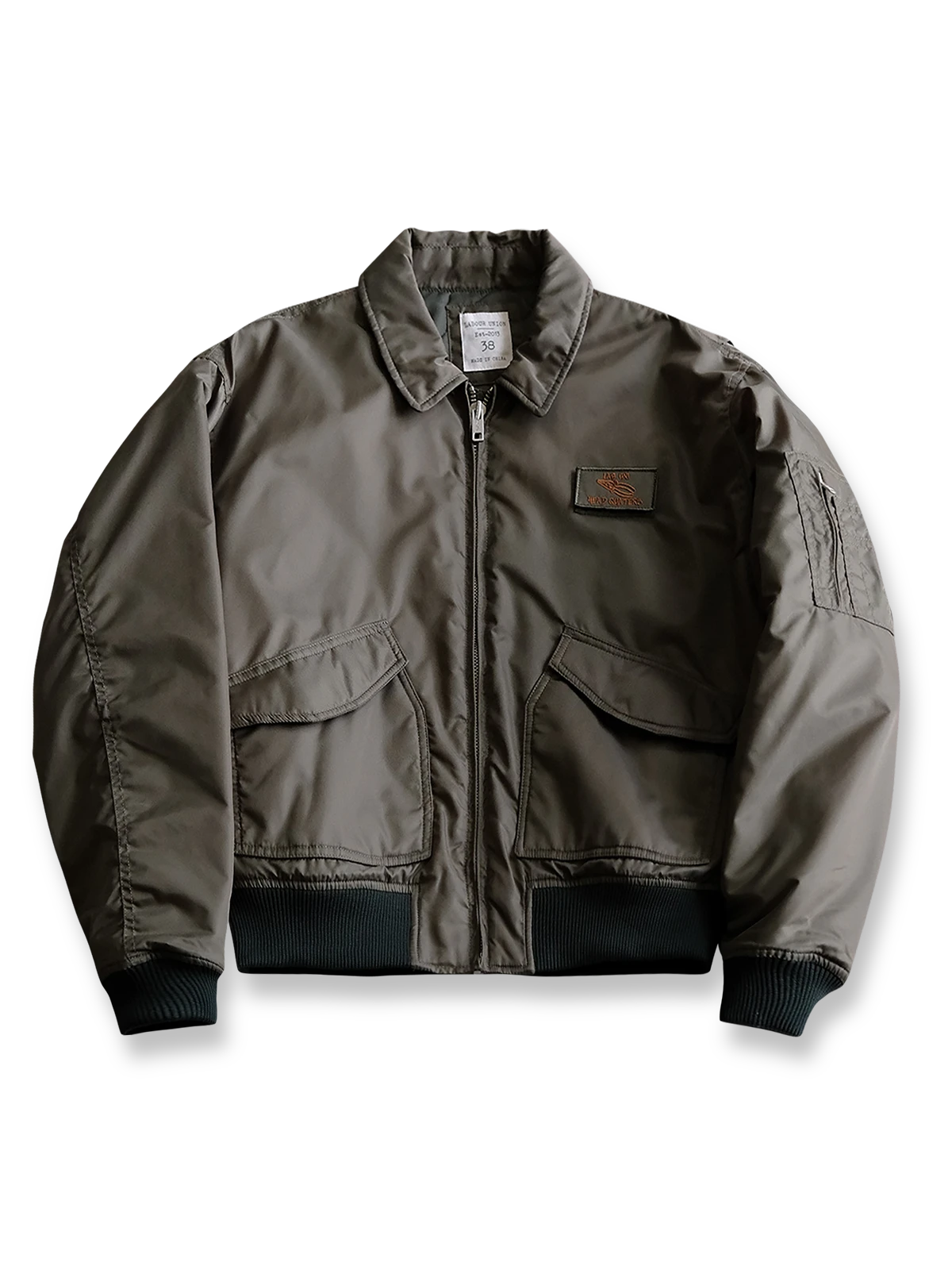 製品画像:
CWU-45Pフライトジャケット全体展示。高密度ナイロン素材と厚手のキルティング綿を使用し、ミリタリースタイルと快適性を兼ね備えたクラシックなデザイン。
詳細画像:
TALONメタルジッパーとマジックテープエンブレムのディテール。レトロ感あふれるエンブレムとジッパーが、クラシックなフライトジャケットの魅力を引き立てます。