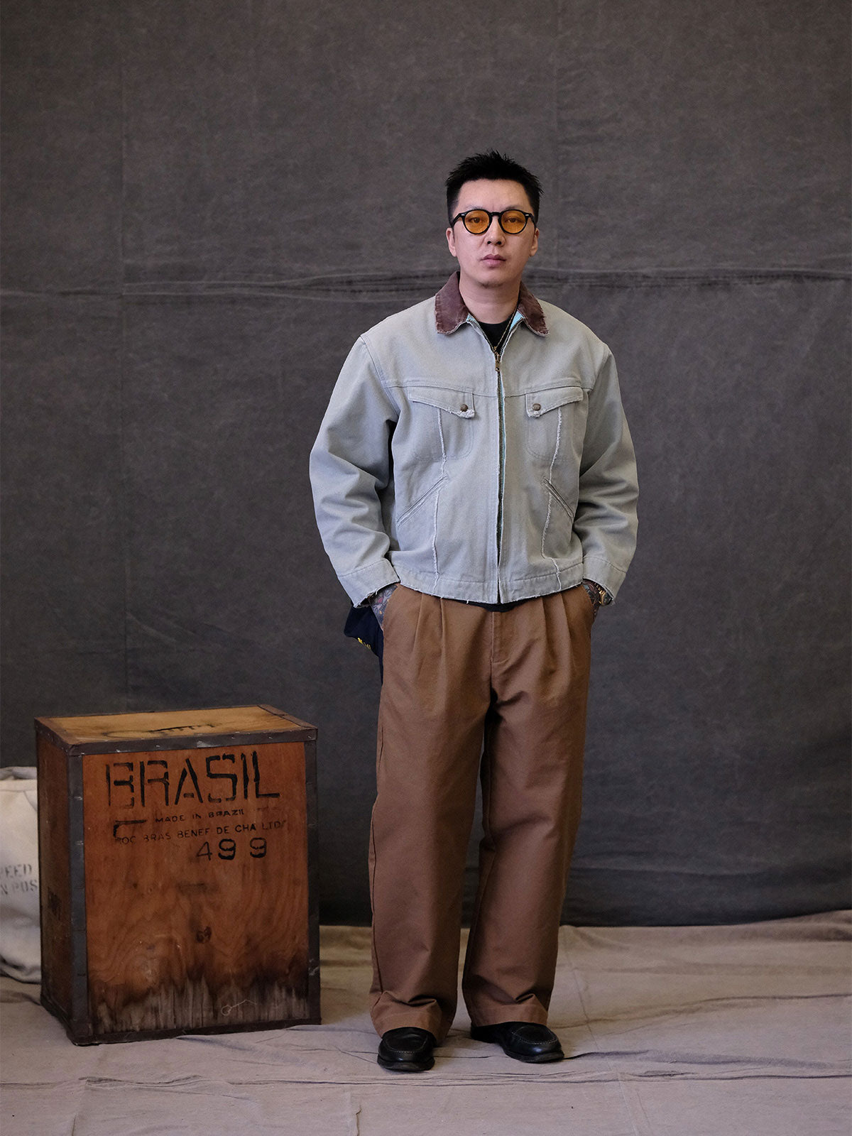 詳細画像:
TALONジッパー、スナップボタン、及び水洗い加工のディテール。多重水洗い加工と手作業のダメージ加工が施された、ヴィンテージ感が強調されたディテール。
モデル画像:
モデルがリバイバルキャンバスジャケットを着用し、カーゴパンツと合わせてアメリカンリバイバルスタイルを演出している画像。