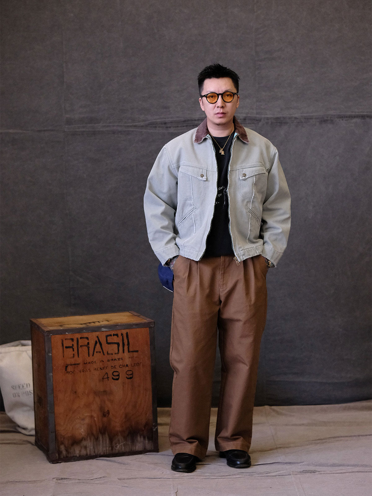 詳細画像:
TALONジッパー、スナップボタン、及び水洗い加工のディテール。多重水洗い加工と手作業のダメージ加工が施された、ヴィンテージ感が強調されたディテール。
モデル画像:
モデルがリバイバルキャンバスジャケットを着用し、カーゴパンツと合わせてアメリカンリバイバルスタイルを演出している画像。