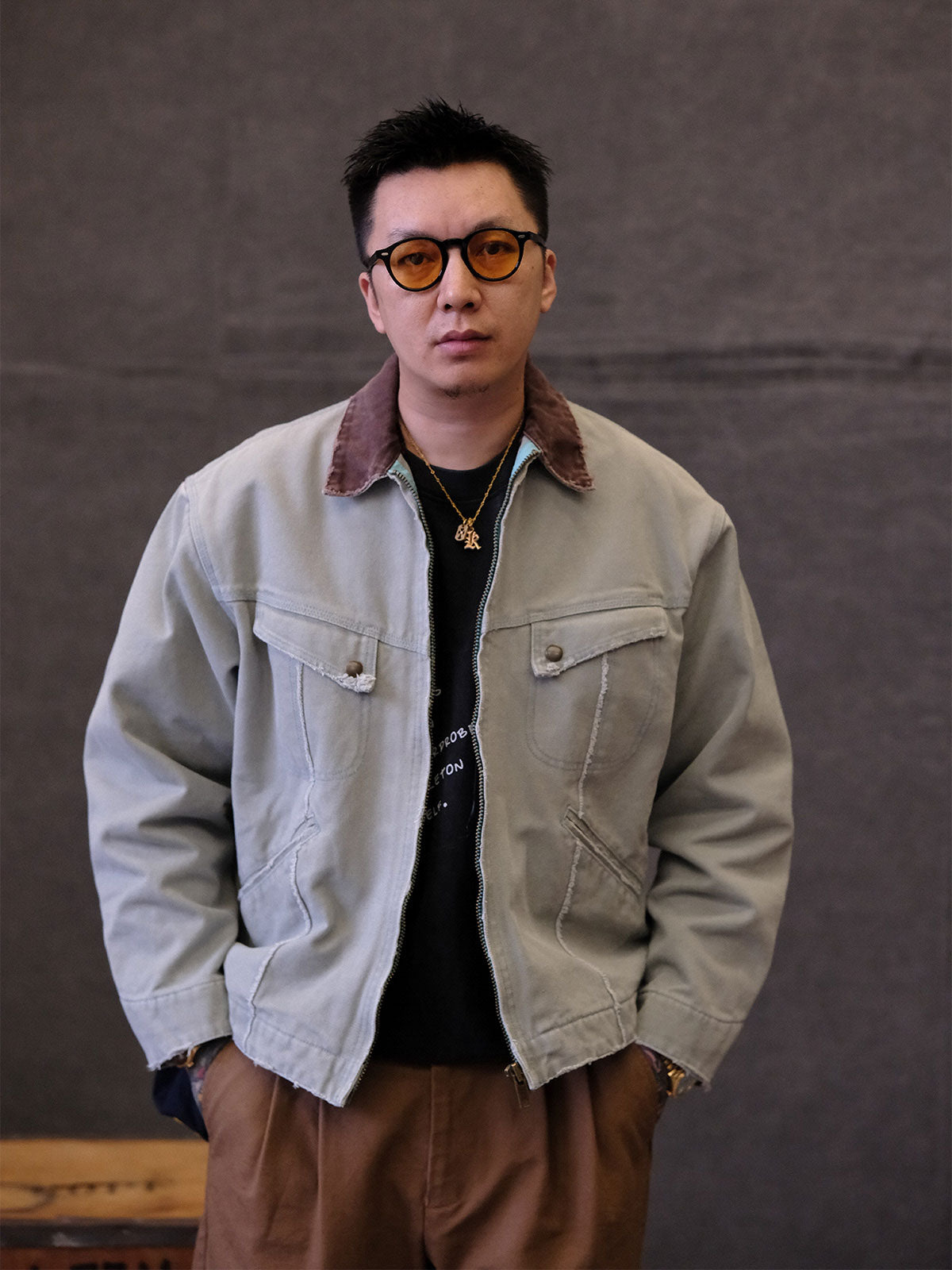 詳細画像:
TALONジッパー、スナップボタン、及び水洗い加工のディテール。多重水洗い加工と手作業のダメージ加工が施された、ヴィンテージ感が強調されたディテール。
モデル画像:
モデルがリバイバルキャンバスジャケットを着用し、カーゴパンツと合わせてアメリカンリバイバルスタイルを演出している画像。