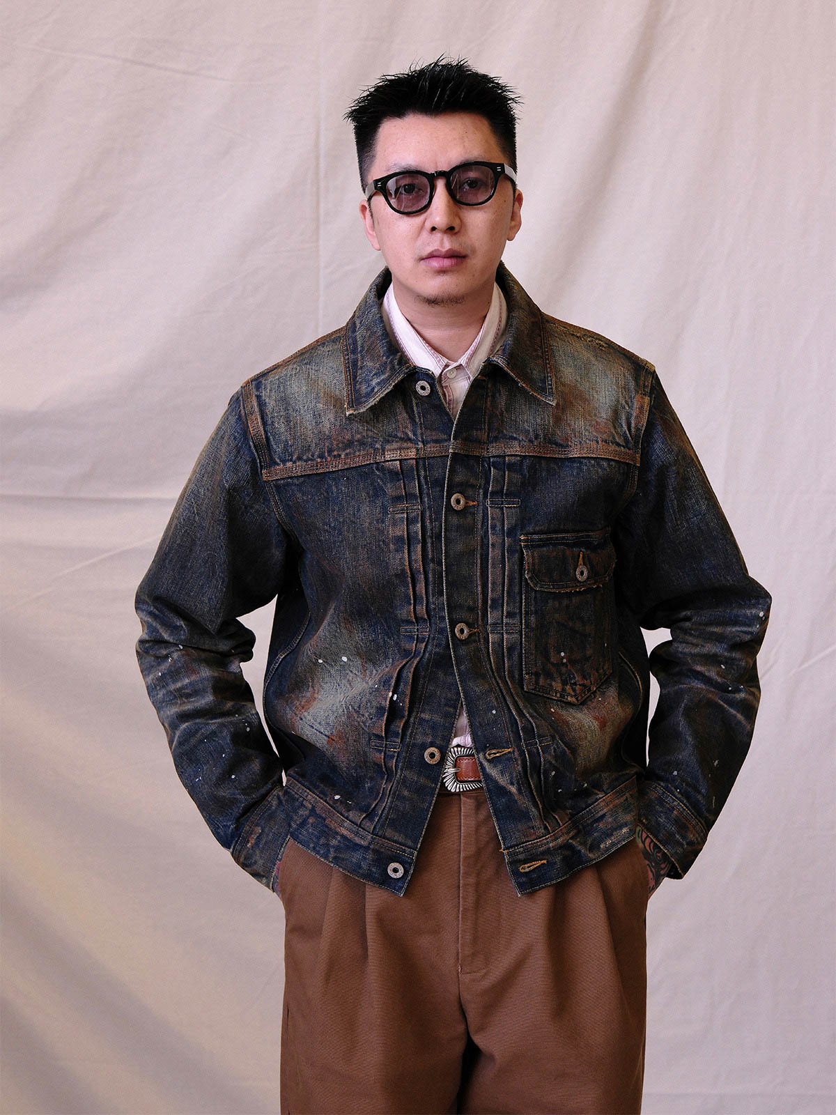 詳細画像:
エッチング加工された真鍮バックルのディテール。精緻な彫刻が施された立体感のあるバックルが、ヴィンテージスタイルの魅力を引き立てるディテール。
モデル画像:
モデルがヴィンテージキャバルリーベルトを着用し、デニムやカーゴパンツと合わせて、アメリカンウェスタンスタイルを披露している画像。