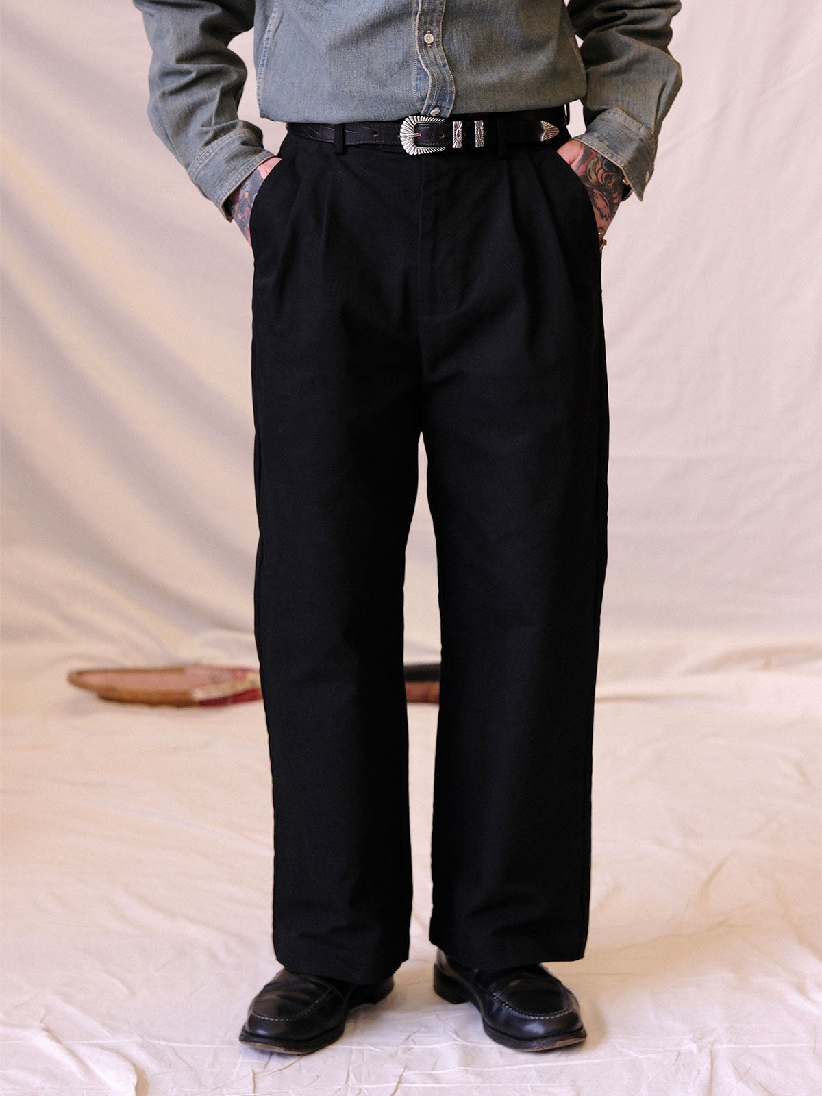 詳細画像:
エッチング加工された真鍮バックルのディテール。精緻な彫刻が施された立体感のあるバックルが、ヴィンテージスタイルの魅力を引き立てるディテール。
モデル画像:
モデルがヴィンテージキャバルリーベルトを着用し、デニムやカーゴパンツと合わせて、アメリカンウェスタンスタイルを披露している画像。