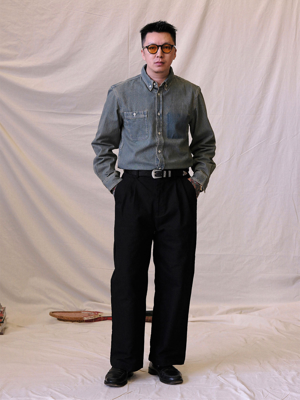 詳細画像:
エッチング加工された真鍮バックルのディテール。精緻な彫刻が施された立体感のあるバックルが、ヴィンテージスタイルの魅力を引き立てるディテール。
モデル画像:
モデルがヴィンテージキャバルリーベルトを着用し、デニムやカーゴパンツと合わせて、アメリカンウェスタンスタイルを披露している画像。