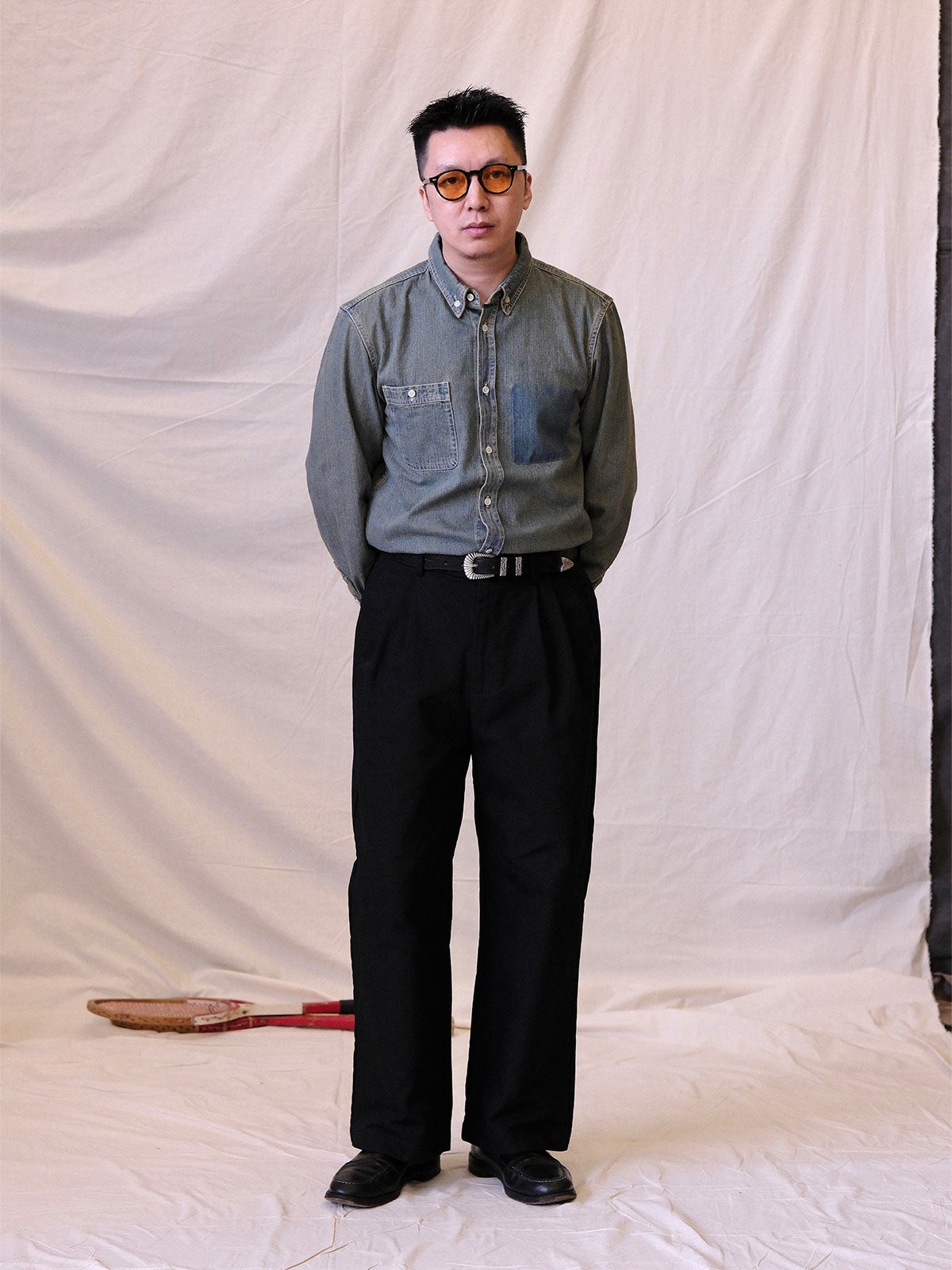 詳細画像:
エッチング加工された真鍮バックルのディテール。精緻な彫刻が施された立体感のあるバックルが、ヴィンテージスタイルの魅力を引き立てるディテール。
モデル画像:
モデルがヴィンテージキャバルリーベルトを着用し、デニムやカーゴパンツと合わせて、アメリカンウェスタンスタイルを披露している画像。