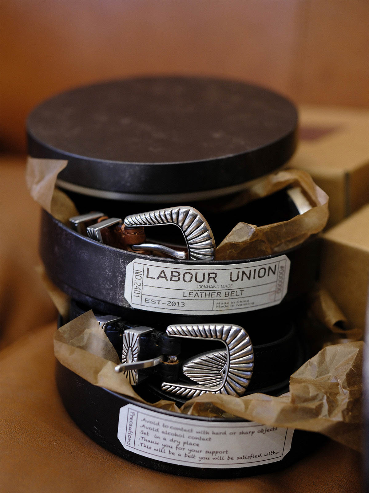 製品画像:
ヴィンテージキャバルリー インポートレザーベルト全景展示。アメリカンウェスタンスタイルにインスパイアされたインポートレザー素材のベルトで、タフでレトロなヴィンテージ感が表現された全体像。
詳細画像:
エッチング加工された真鍮バックルのディテール。精緻な彫刻が施された立体感のあるバックルが、ヴィンテージスタイルの魅力を引き立てるディテール。