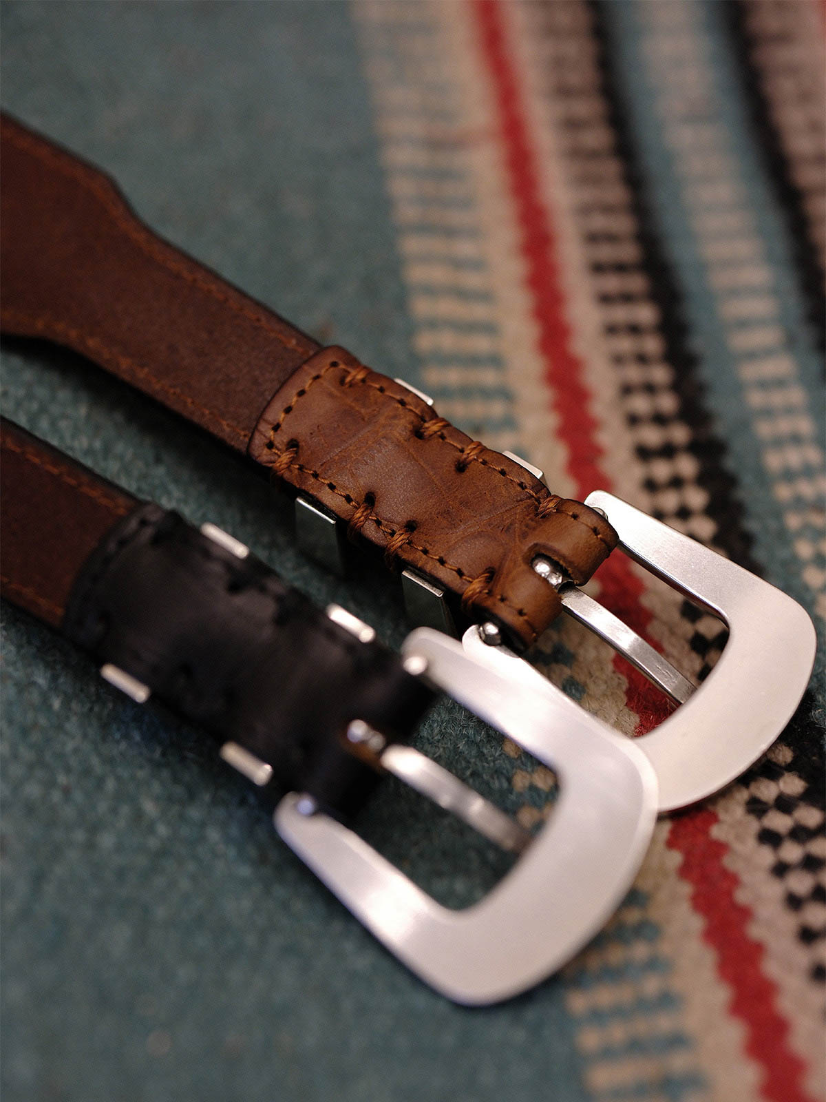 製品画像:
ヴィンテージキャバルリー インポートレザーベルト全景展示。アメリカンウェスタンスタイルにインスパイアされたインポートレザー素材のベルトで、タフでレトロなヴィンテージ感が表現された全体像。
詳細画像:
エッチング加工された真鍮バックルのディテール。精緻な彫刻が施された立体感のあるバックルが、ヴィンテージスタイルの魅力を引き立てるディテール。