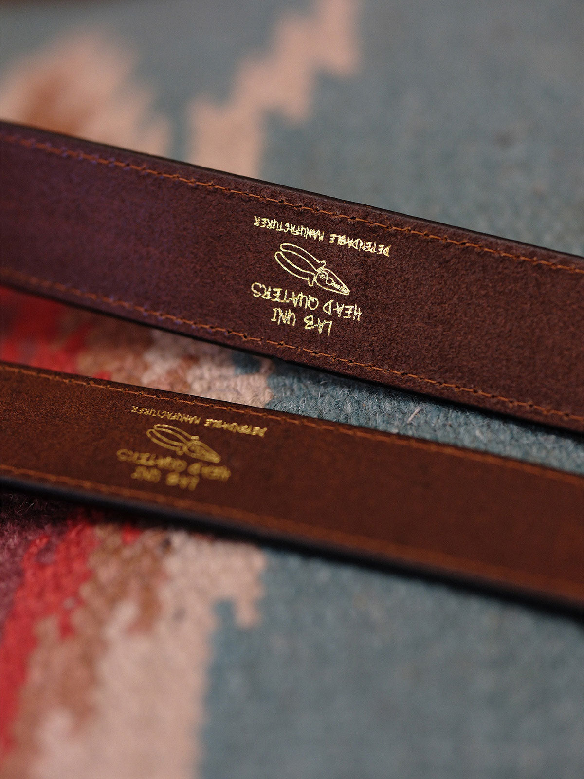 製品画像:
ヴィンテージキャバルリー インポートレザーベルト全景展示。アメリカンウェスタンスタイルにインスパイアされたインポートレザー素材のベルトで、タフでレトロなヴィンテージ感が表現された全体像。
詳細画像:
エッチング加工された真鍮バックルのディテール。精緻な彫刻が施された立体感のあるバックルが、ヴィンテージスタイルの魅力を引き立てるディテール。