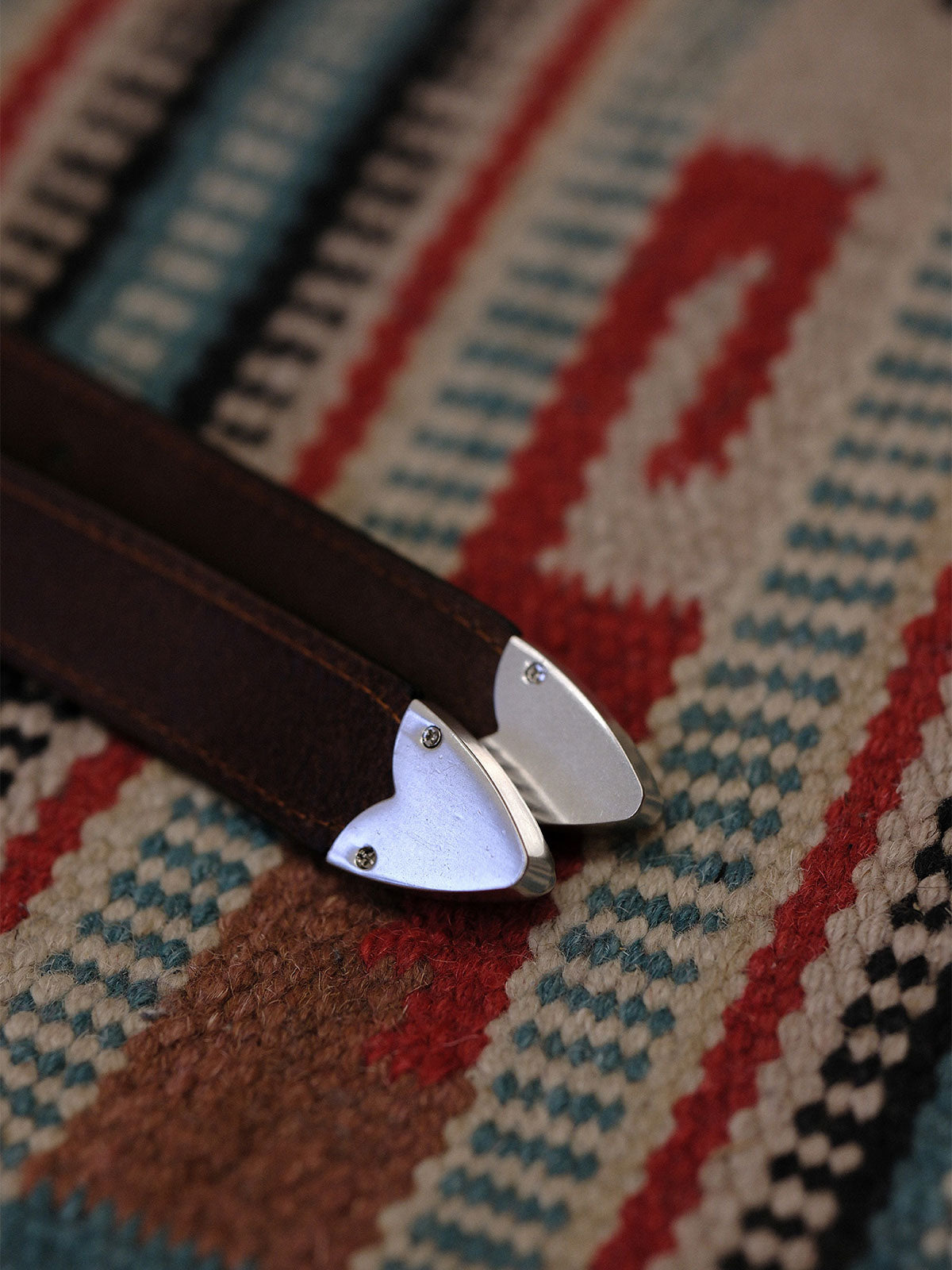 製品画像:
ヴィンテージキャバルリー インポートレザーベルト全景展示。アメリカンウェスタンスタイルにインスパイアされたインポートレザー素材のベルトで、タフでレトロなヴィンテージ感が表現された全体像。
詳細画像:
エッチング加工された真鍮バックルのディテール。精緻な彫刻が施された立体感のあるバックルが、ヴィンテージスタイルの魅力を引き立てるディテール。