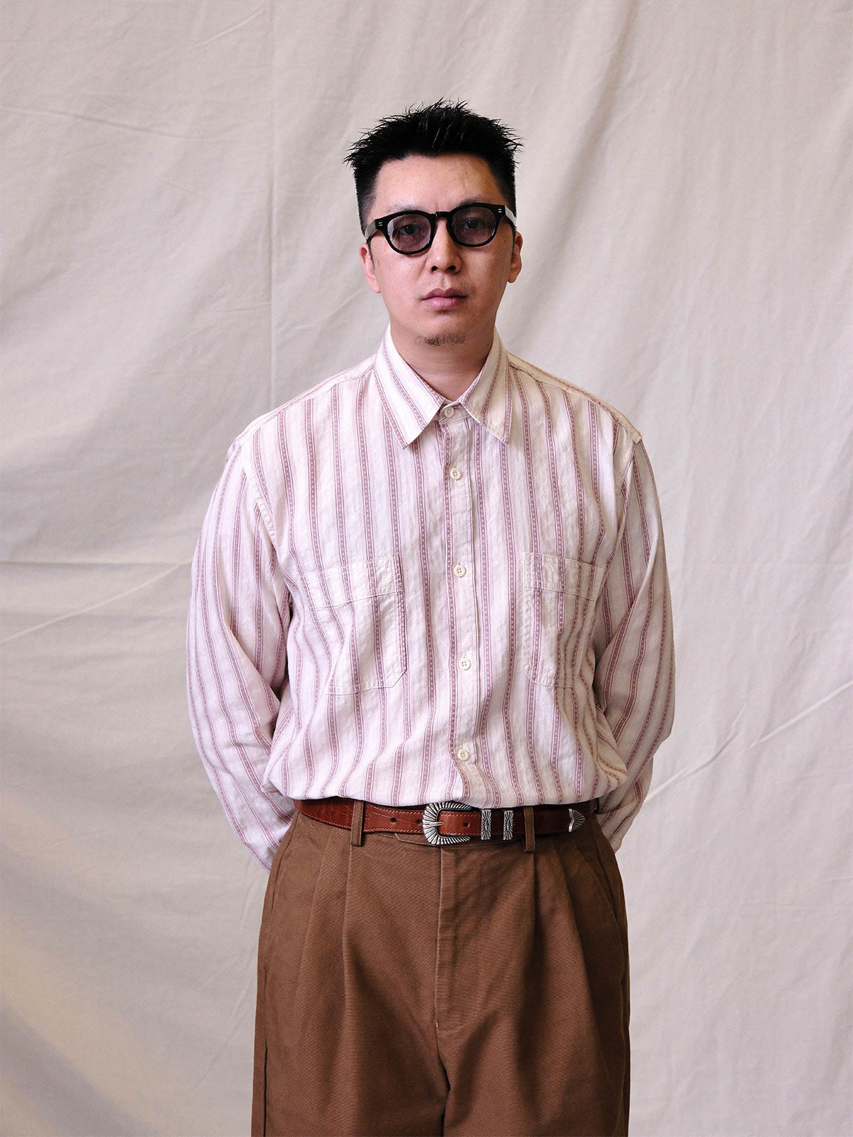 詳細画像:
エッチング加工された真鍮バックルのディテール。精緻な彫刻が施された立体感のあるバックルが、ヴィンテージスタイルの魅力を引き立てるディテール。
モデル画像:
モデルがヴィンテージキャバルリーベルトを着用し、デニムやカーゴパンツと合わせて、アメリカンウェスタンスタイルを披露している画像。