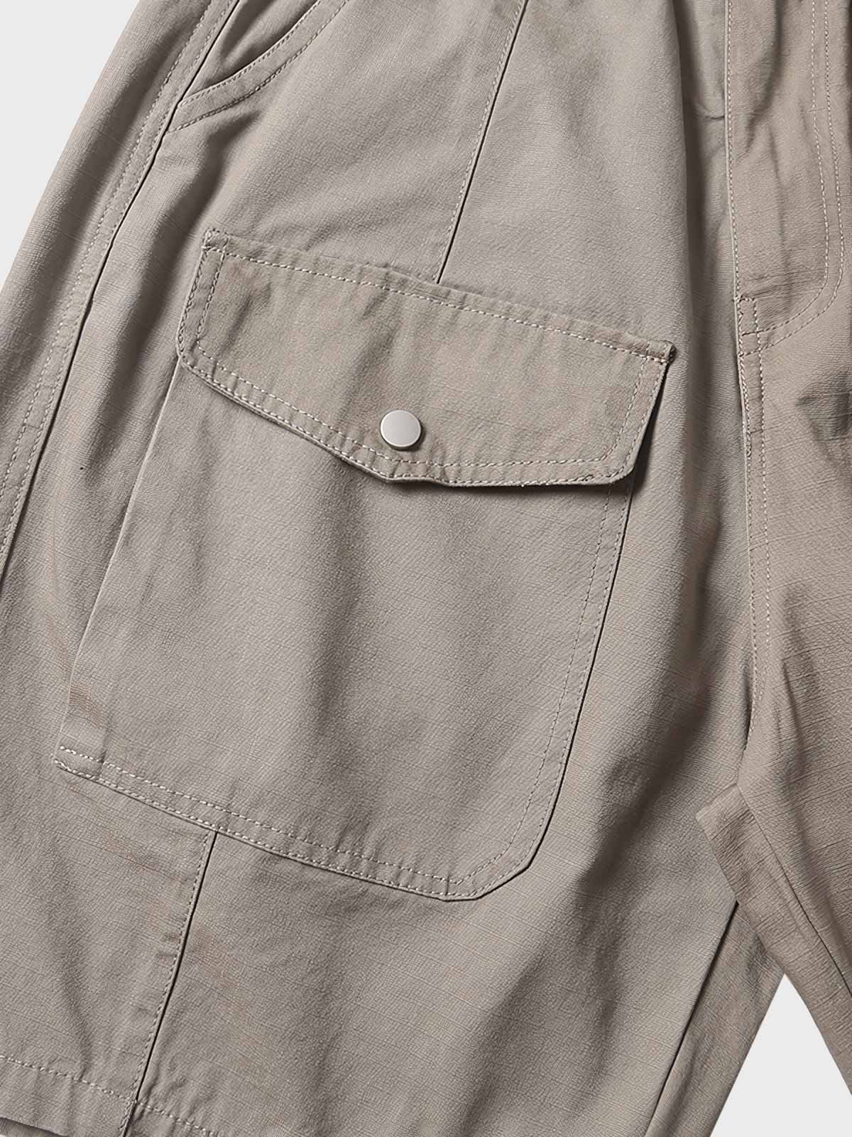 ショートパンツの細部に注目した画像、多機能ポケットとスナップボタンのクローズアップ。