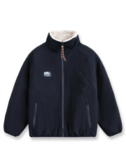 製品画像: リバーシブル シープスキン 中綿ジャケット。柔らかなシープスキンと耐久性のある織りナイロン素材を組み合わせた、多用途デザインの正面全体展示図。

詳細画像: バイカラーデザインと多機能ポケット、さらにハイネック仕様が特徴のリバーシブルジャケットのディテールクローズアップ。