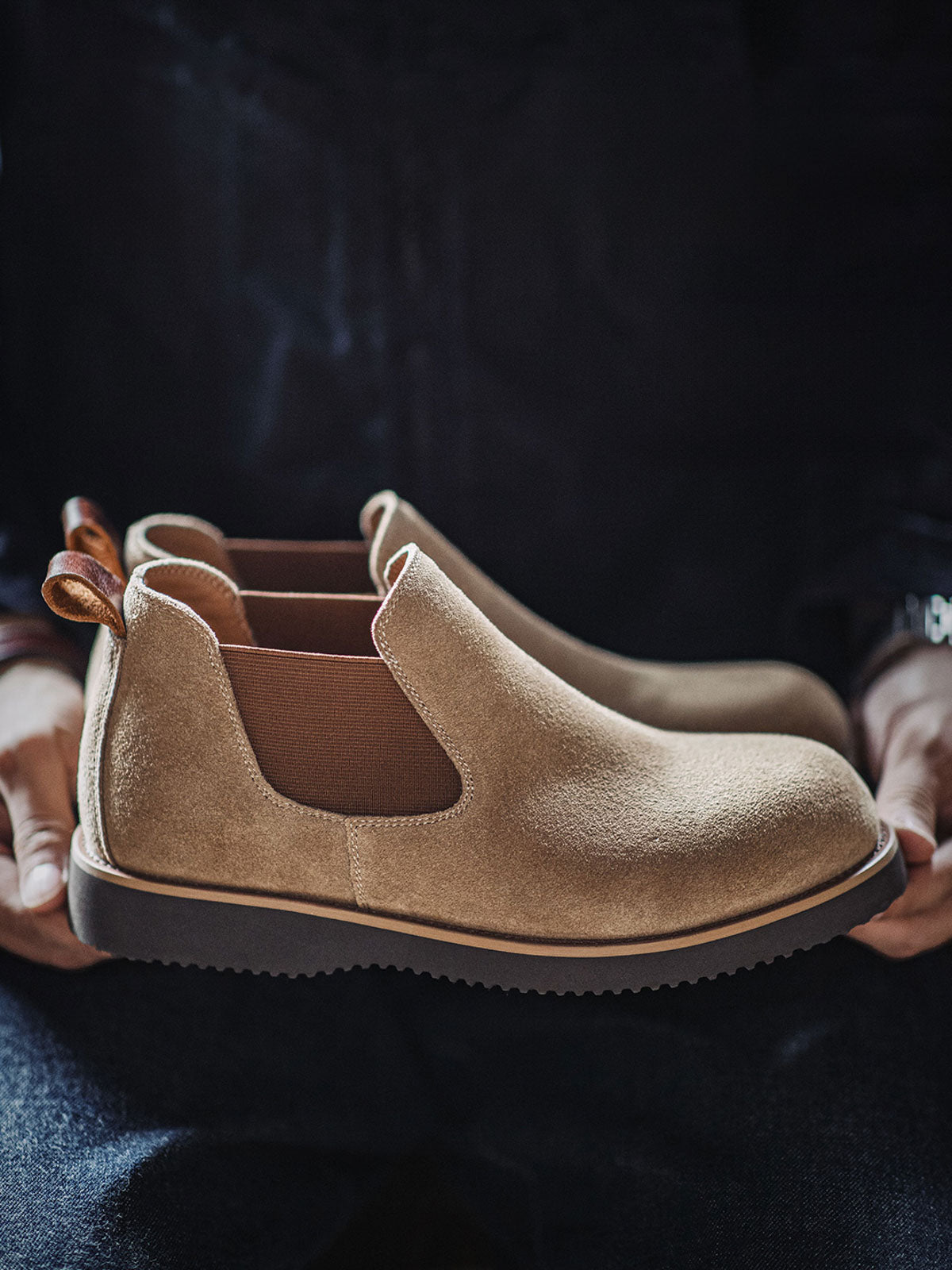 製品画像:
ライトブラウンのスエードチェルシーブーツ全体画像。シンプルで洗練されたデザインが特徴で、秋冬シーズンに最適なスタイルを提案します。

詳細画像:
チェルシーブーツのゴムバンドとスエードの質感がクローズアップされたディテール画像。履きやすさとデザインの美しさが強調されています。