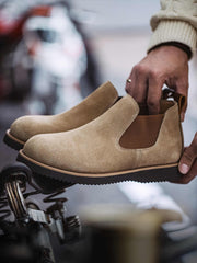 製品画像:
ライトブラウンのスエードチェルシーブーツ全体画像。シンプルで洗練されたデザインが特徴で、秋冬シーズンに最適なスタイルを提案します。

詳細画像:
チェルシーブーツのゴムバンドとスエードの質感がクローズアップされたディテール画像。履きやすさとデザインの美しさが強調されています。