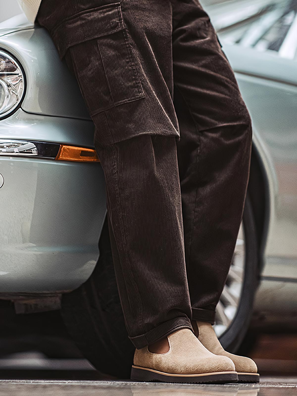 詳細画像:
チェルシーブーツのゴムバンドとスエードの質感がクローズアップされたディテール画像。履きやすさとデザインの美しさが強調されています。

モデル画像:
モデルがライトブラウンスエードチェルシーブーツを履いたスタイル。カジュアルからワークスタイルまで、多様なコーディネートに対応可能なアイテムです。