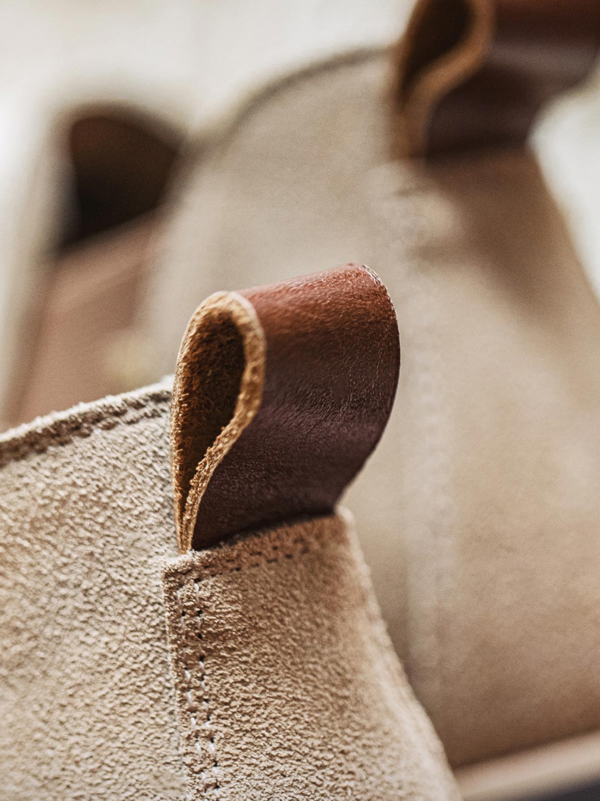 製品画像:
ライトブラウンのスエードチェルシーブーツ全体画像。シンプルで洗練されたデザインが特徴で、秋冬シーズンに最適なスタイルを提案します。

詳細画像:
チェルシーブーツのゴムバンドとスエードの質感がクローズアップされたディテール画像。履きやすさとデザインの美しさが強調されています。