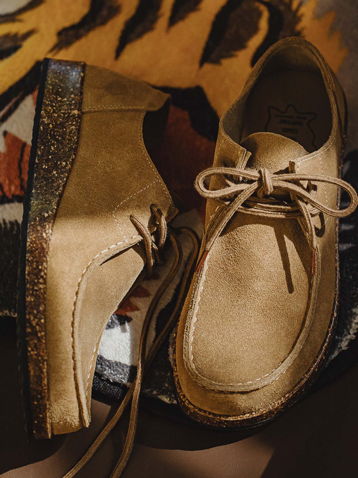 製品画像: ヴィンテージ風スエードレザーカンガルーシューズのサイドビュー展示。60年代のクラシックデザインが特徴的。
詳細画像: コルク粒入りミッドソールと波形ラバーアウトソールのディテール展示で、快適な履き心地を提供。