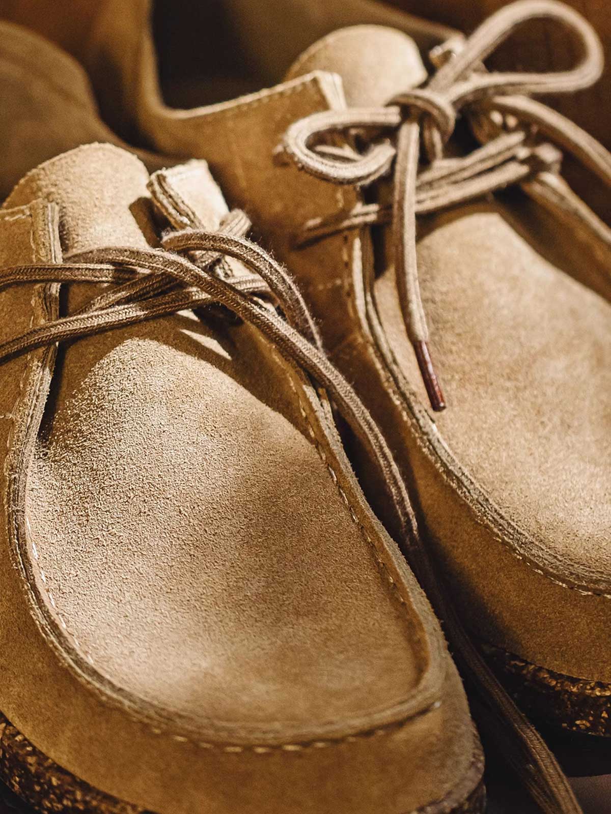 製品画像: ヴィンテージ風スエードレザーカンガルーシューズのサイドビュー展示。60年代のクラシックデザインが特徴的。
詳細画像: コルク粒入りミッドソールと波形ラバーアウトソールのディテール展示で、快適な履き心地を提供。