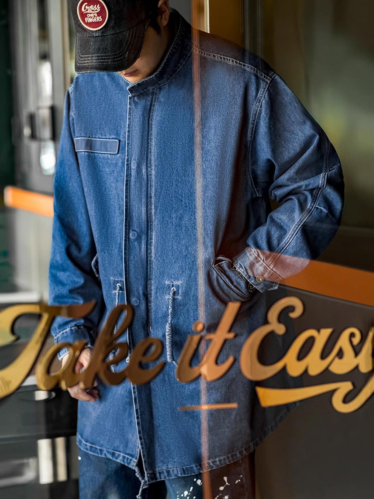 詳細画像: フィッシュテールデザインとウエストドローコードのディテール。調整可能なシルエットで、快適なフィット感を提供
モデル画像: モデルが着用したM65デニムフィッシュテールコートの全身スタイリング。秋のストリートカジュアルに最適なルーズフィットシルエット