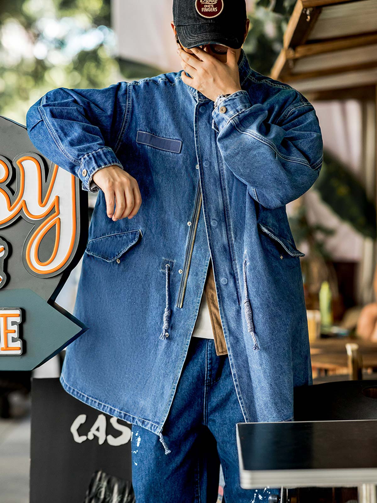 詳細画像: フィッシュテールデザインとウエストドローコードのディテール。調整可能なシルエットで、快適なフィット感を提供
モデル画像: モデルが着用したM65デニムフィッシュテールコートの全身スタイリング。秋のストリートカジュアルに最適なルーズフィットシルエット