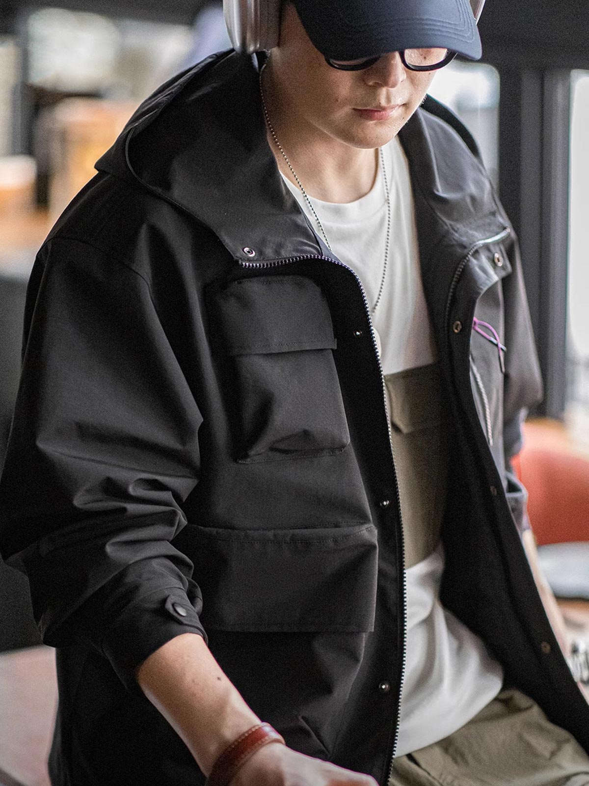 詳細画像: グロメットジッパーとレインシェルデザインのディテール、防護性能
モデル画像: モデル着用 テクニカルジャケット 全身、Gorpcoreスタイルに最適