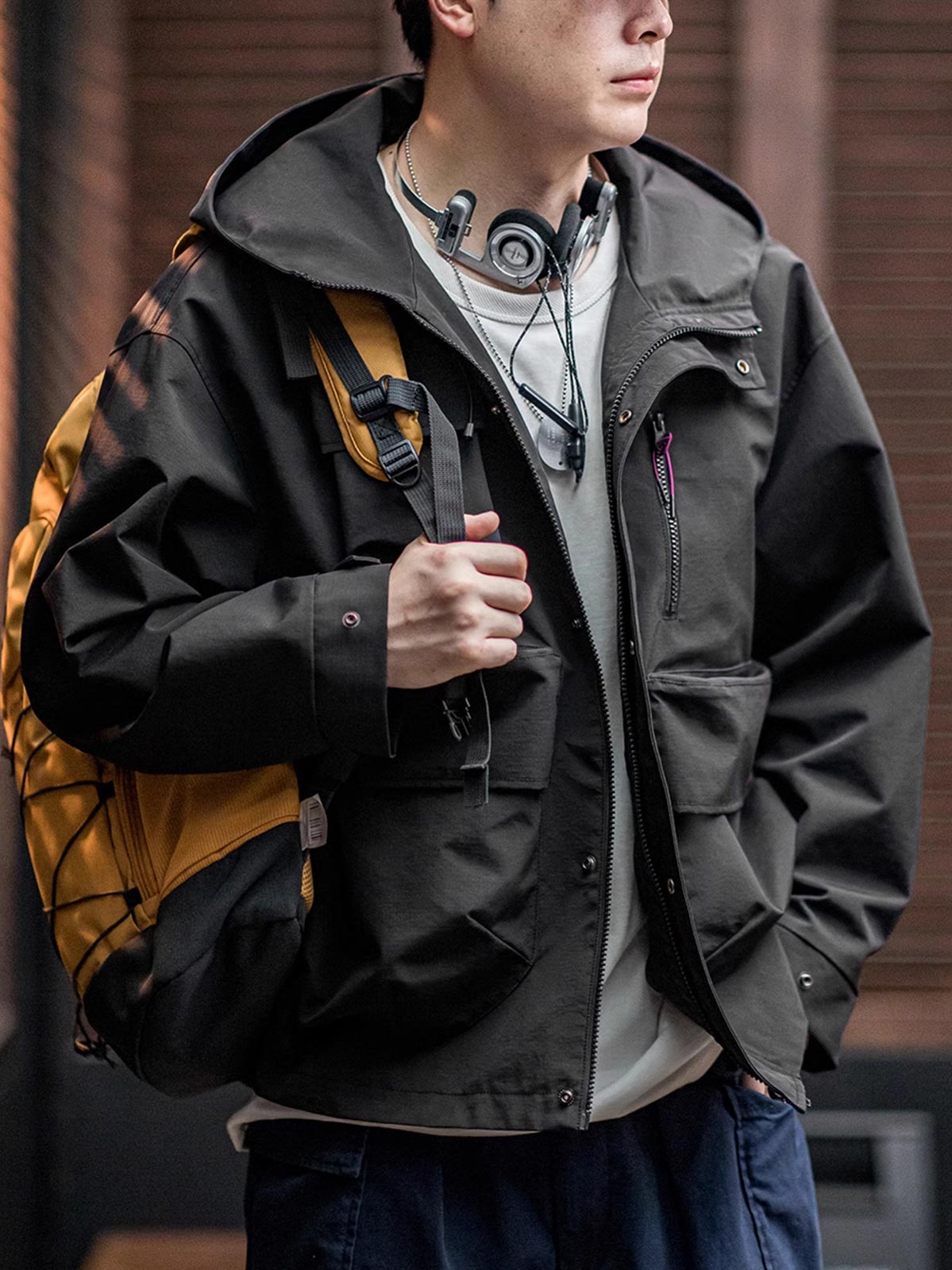 詳細画像: グロメットジッパーとレインシェルデザインのディテール、防護性能
モデル画像: モデル着用 テクニカルジャケット 全身、Gorpcoreスタイルに最適