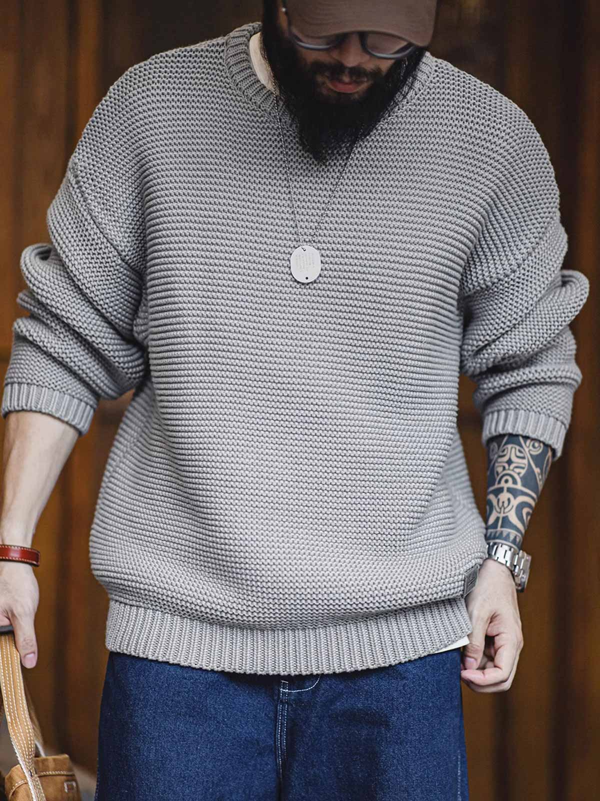 詳細画像: ニットの編み目が立体的に見えるディテール画像。粗い糸で編まれた質感が、ヴィンテージ調の雰囲気を引き出し、耐久性の高さと毛玉の付きにくさを表現。

モデル画像: モデルがヴィンテージ風の重厚な厚手テクスチャーニットセーターを着用している様子。スマイルカーブネックのデザインが映え、ゆったりとしたドロップショルダーで、冬のレイヤードコーディネートにも最適なシルエット。