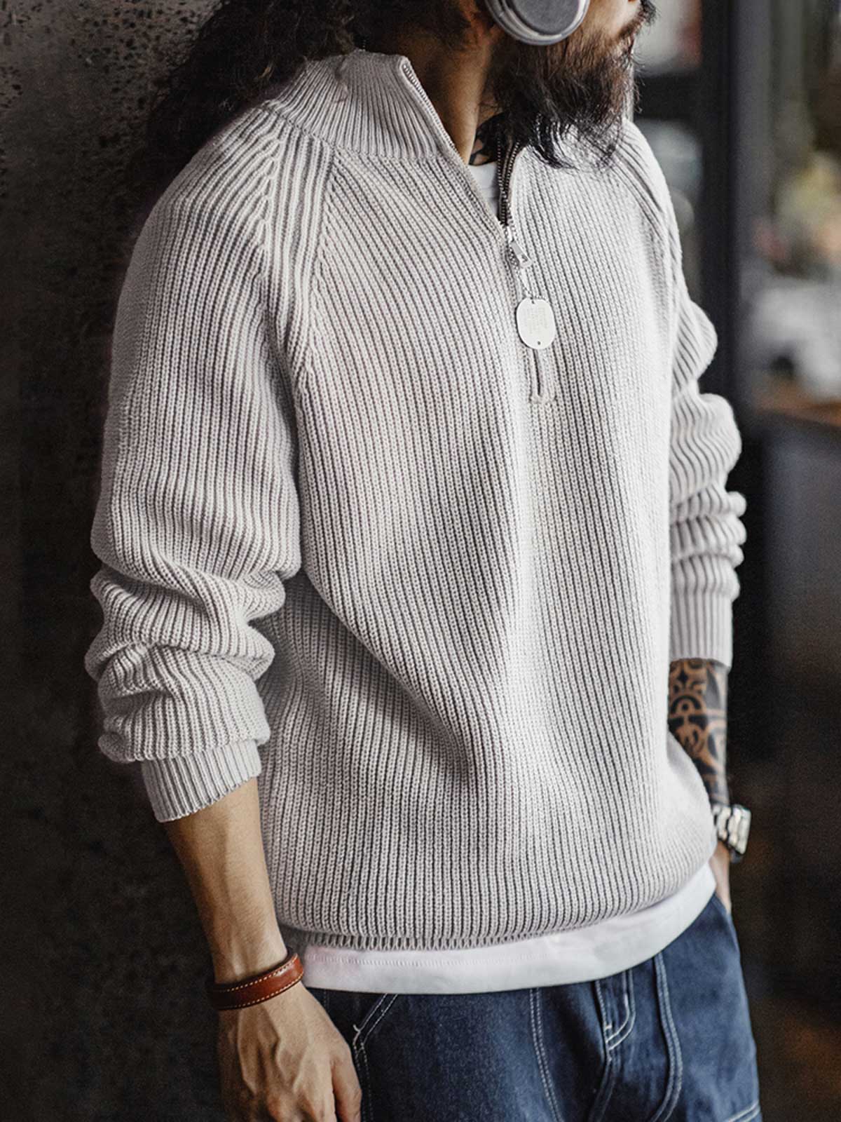 詳細画像: ハーフジップと縦リブの珠編みテクスチャーのディテール表示。しっかりとした編み地が立体感を生み、ヴィンテージ感が引き立つ仕上がり。

モデル画像: モデル着用のヴィンテージスタイルのニットセーター。レイヤードにも一枚でも楽しめる、クラシックな着こなし。