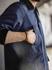 詳細画像：イギリスチェックの裏地と黒のコーデュロイラペルのディテール展示。クラシックなアクセントがコート全体に深いインプレッションをもたらす。
モデル画像：モデルがオーバーサイズのレトロハンティング風コートを着用し、袖口を巻き上げたスタイル。ブーツと合わせてアメリカンワークテイストを演出。
