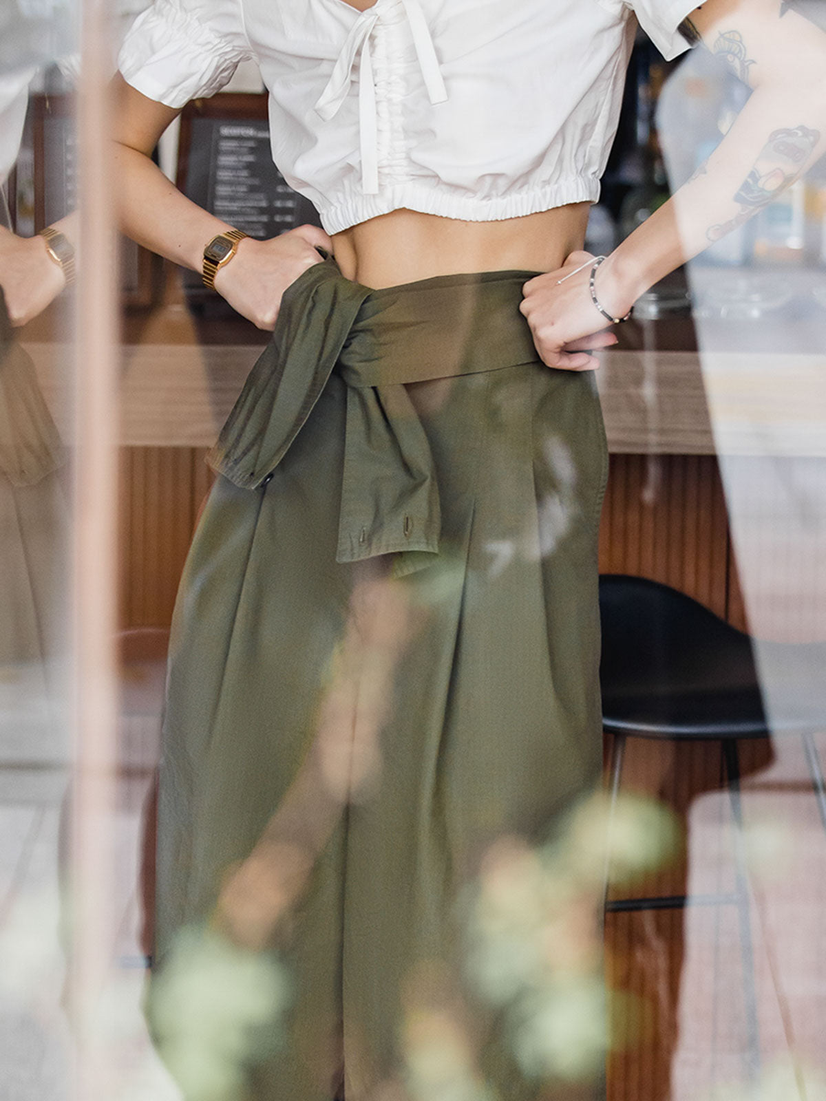 モデルがミリタリーグリーンのワイドレッグカジュアルサロペットを着用し、異なるスタイリング方法を披露。