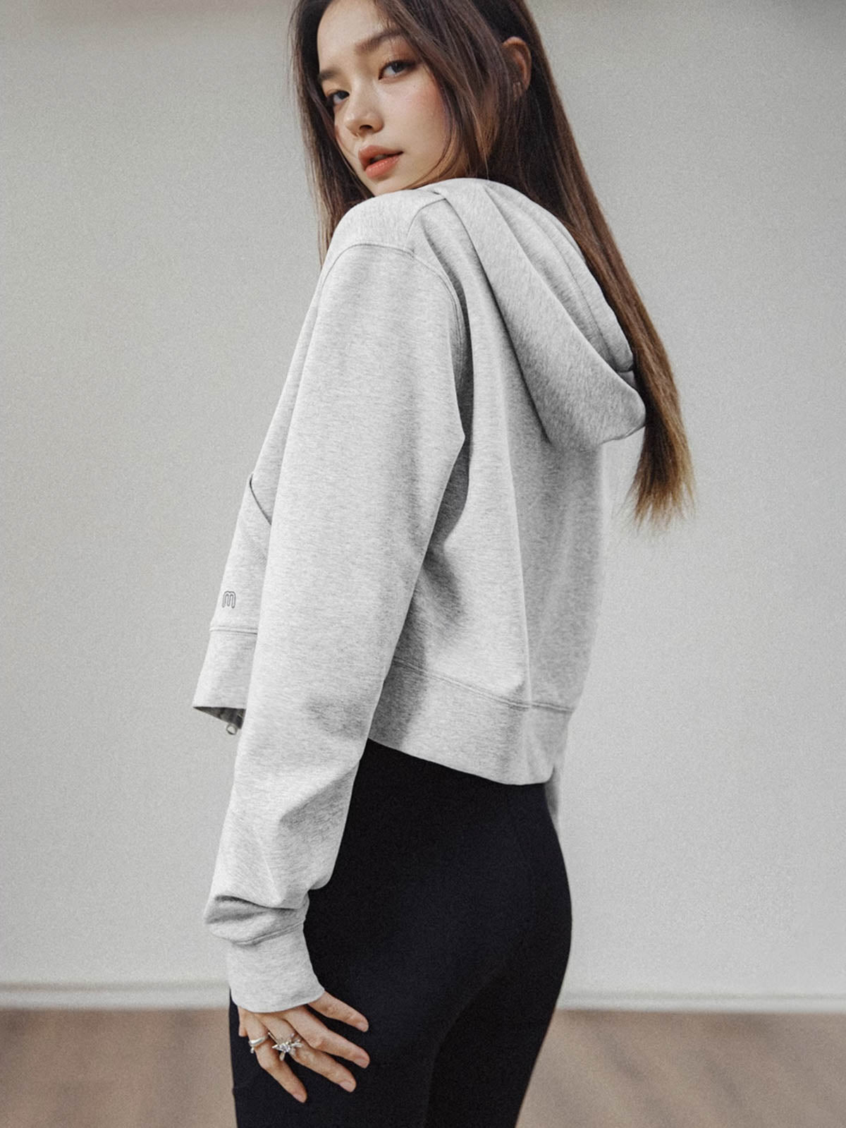 モデルがアメリカンストリートスタイルのグレーショート丈フーディージップアップを着用し、多様なスタイリングを披露