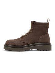 製品画像：
1960年代のマーチンブーツをインスパイアしたワイルドライフ風ダークブラウンスエード作業靴。ダークブラウンのスエードレザーとキャンバス素材を組み合わせ、自然な風合いと耐久性を提供。手縫いのマークスティッチやアクセントカラーのイヤータブがディテールにこだわりを感じさせます。

詳細画像：
ダークブラウンスエードレザーの靴に、耐久性を高める洗い加工したキャンバスを使用。しっかりとした靴筒と履き口のデザイン、手縫いのマークスティッチ、上部の牛革タグが特徴。