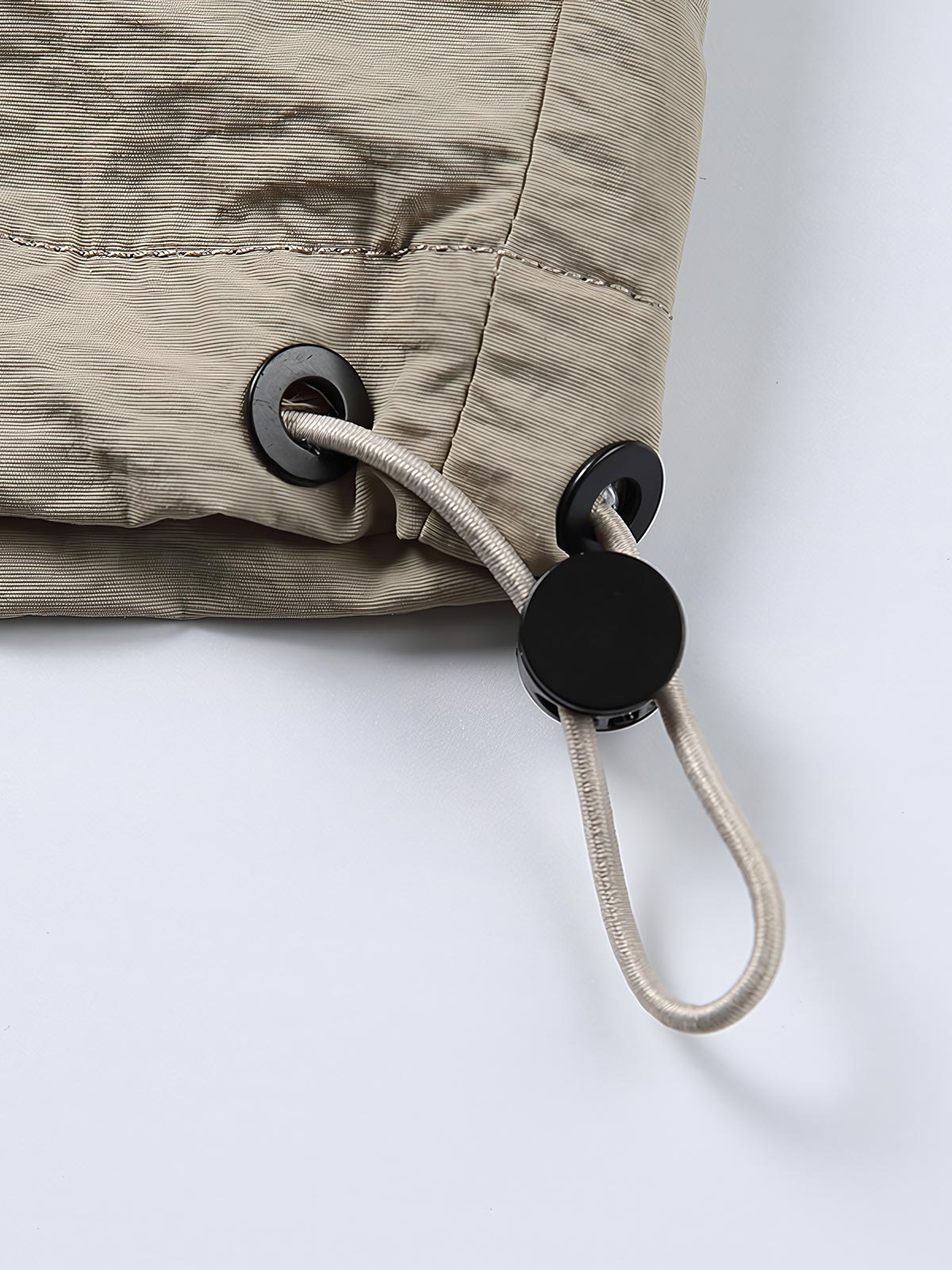 製品画像: 両脇ポケットとウエストのドローストリングが特徴のシンプルなフラップジャケット。
詳細画像: 両脇ポケットとウエストのドローストリングディテールをクローズアップ。