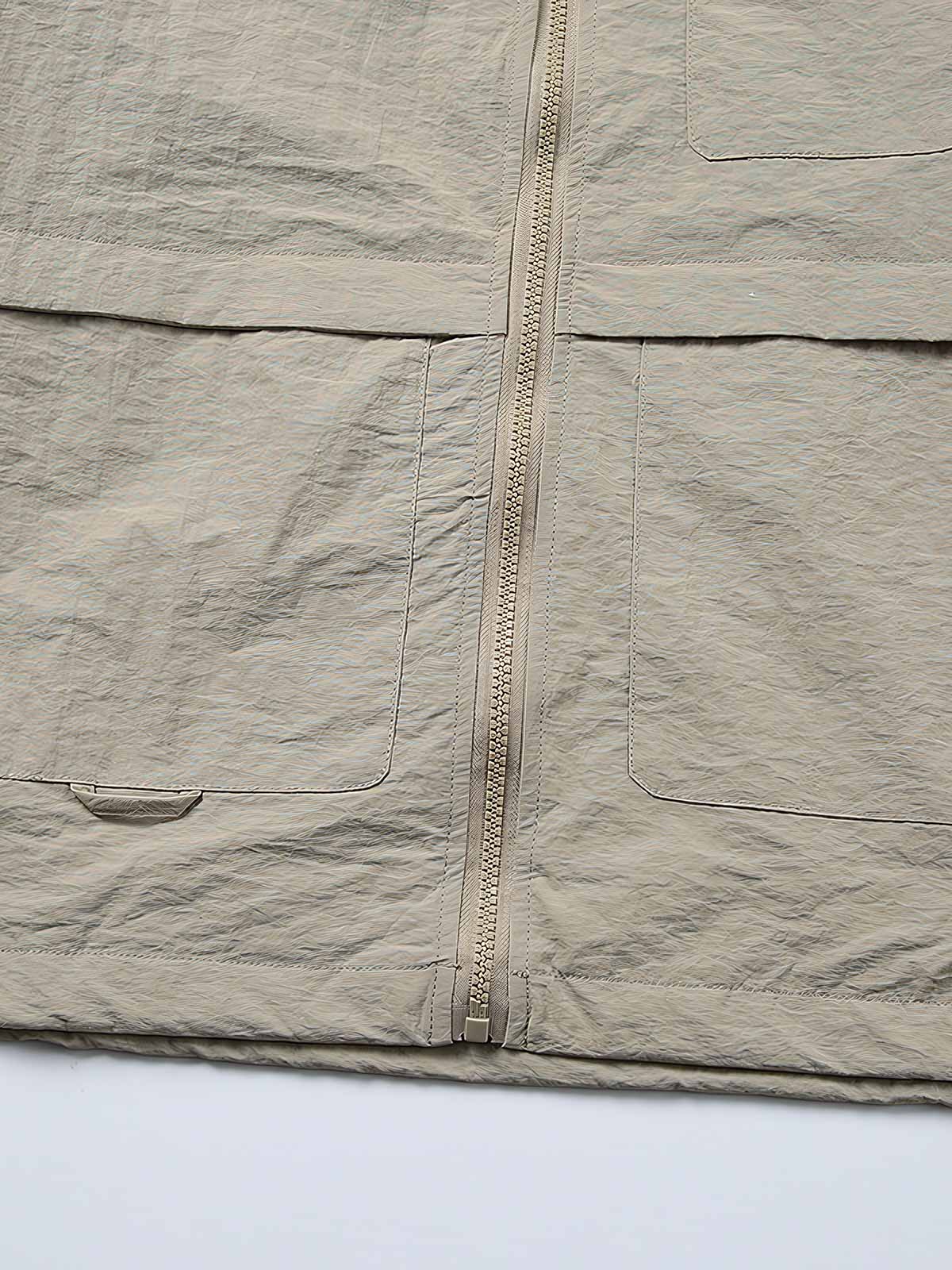 製品画像: 両脇ポケットとウエストのドローストリングが特徴のシンプルなフラップジャケット。
詳細画像: 両脇ポケットとウエストのドローストリングディテールをクローズアップ。