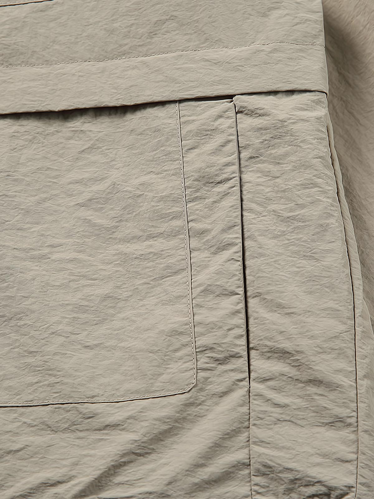 製品画像: 両脇ポケットとウエストのドローストリングが特徴のシンプルなフラップジャケット。
詳細画像: 両脇ポケットとウエストのドローストリングディテールをクローズアップ。