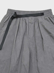 カジュアルパンツのドローコードとパッチワークディテールのクローズアップ。素材の耐久性と細部の工夫が見て取れる、機能的でスタイリッシュなデザイン。