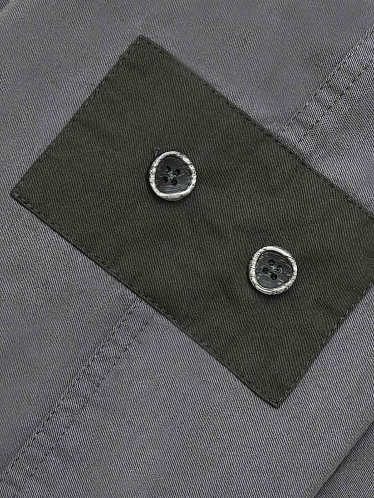 カジュアルパンツのドローコードとパッチワークディテールのクローズアップ。素材の耐久性と細部の工夫が見て取れる、機能的でスタイリッシュなデザイン。