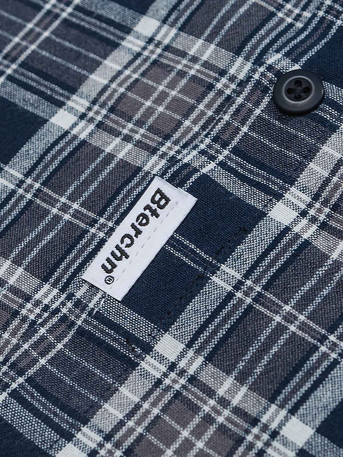 ブルー＆ホワイトチェック柄シャツのピュアコットン素材のクローズアップ。柔らかな肌触りと優れた耐久性を示す。