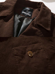 製品画像
「テーラードカラー シングルブレスト ワークジャケットの正面全体図。クラシックなテーラードカラーとシンプルなシングルブレストデザインを融合し、高密度ツイルコットン素材を使用した耐久性と快適さを兼ね備えた一着。深みのあるブラウンカラーがヴィンテージ感を引き立て、カジュアルからフォーマルまで幅広いスタイルに対応。」

詳細画像
「テーラードカラー シングルブレスト ワークジャケットのディテール特写。非対称のフラップポケットが視覚的なアクセントとなり、日常の収納ニーズにも対応。高密度ツイルコットン素材がもたらす柔らかな肌触りと深みのあるブラウンカラーが特徴的で、丁寧な縫製が品質の高さを示している。」