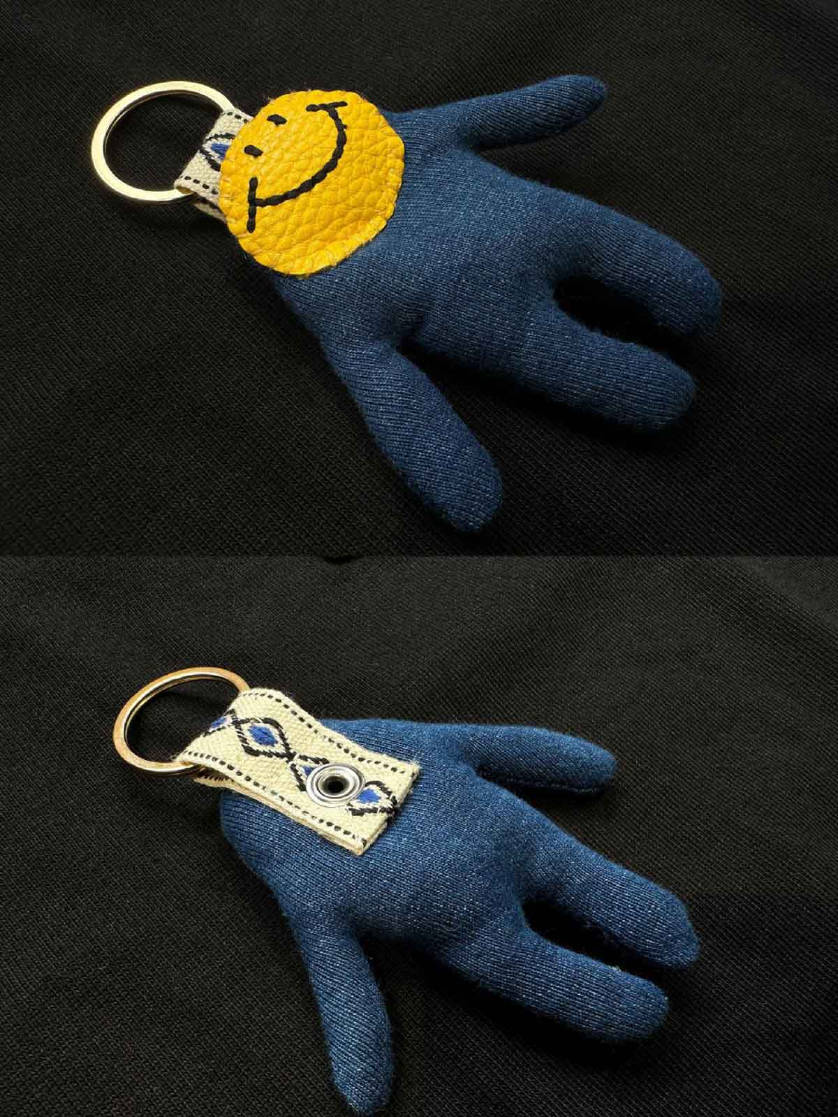 Tシャツのポケットに収められた取り外し可能なスマイルのドールのクローズアップ。ポケットから顔をのぞかせるユニークなデザインが見える。