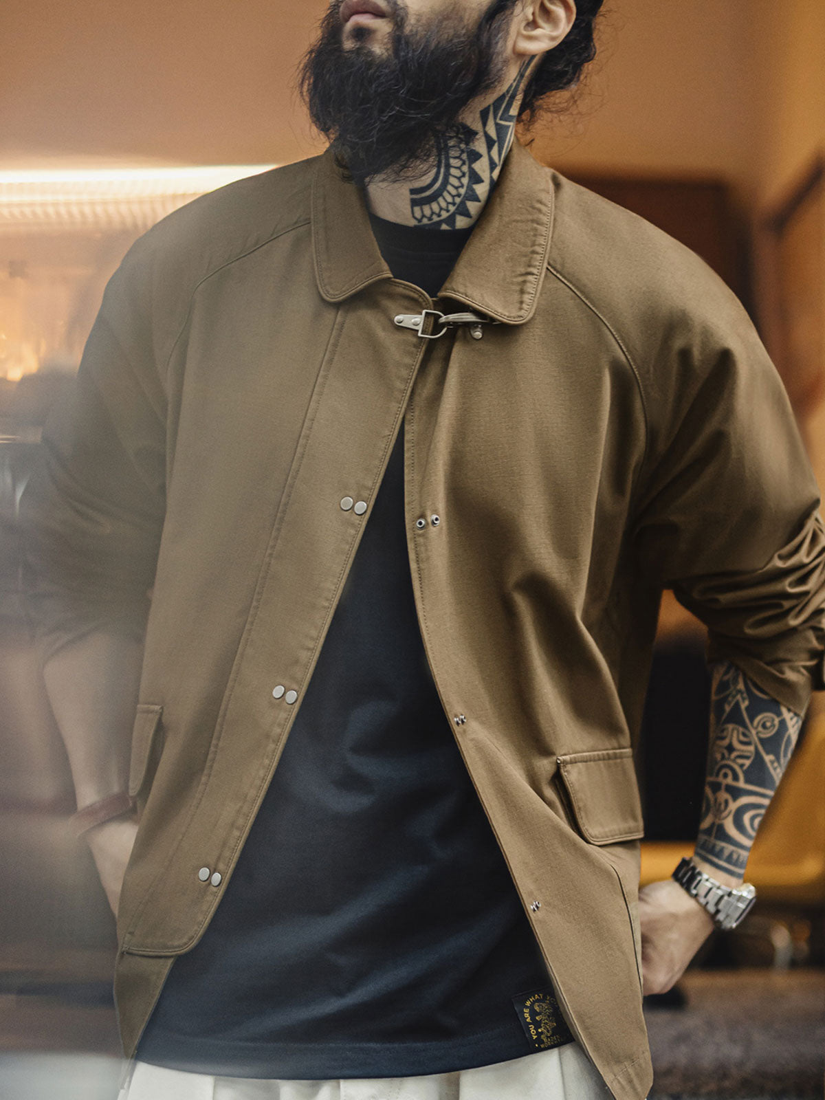 詳細画像
金属製ロブスタークランプとラグランスリーブのディテール、背中の中央縫い合わせデザイン、ブラウンコットン素材で厚手で耐久性があり、通気性も確保

モデル画像
消防バックルキャンバスジャケットを着用したモデル、ユニークなロブスタークランプとラグランスリーブのデザイン、快適で活動的な着心地を提供するルーズフィットスタイル