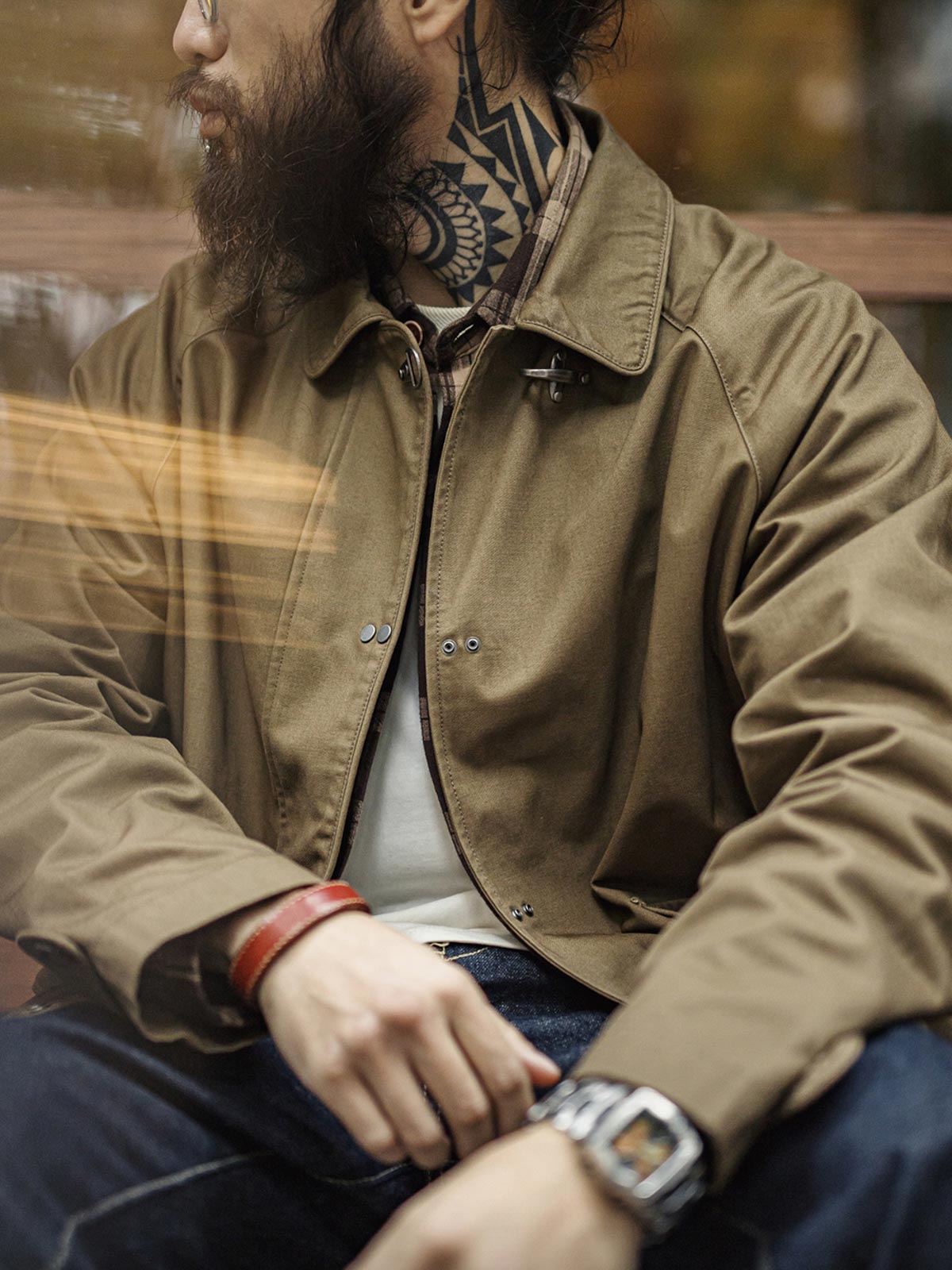 詳細画像
金属製ロブスタークランプとラグランスリーブのディテール、背中の中央縫い合わせデザイン、ブラウンコットン素材で厚手で耐久性があり、通気性も確保

モデル画像
消防バックルキャンバスジャケットを着用したモデル、ユニークなロブスタークランプとラグランスリーブのデザイン、快適で活動的な着心地を提供するルーズフィットスタイル