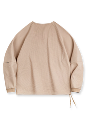 製品画像
立体感のあるワッフル編み素材を採用したヘンリーネックシャツの全体画像。ヴィンテージ感あふれるY字型ボタン付きデザインが特徴で、日常のカジュアルコーデやレイヤードスタイルにも最適。

詳細画像
幾何学模様のワッフル編みテクスチャー、袖口のリブディテール、裾のドローストリングデザインを強調したクローズアップ画像。ラグランスリーブと切り替えデザインが動きと立体感を演出。