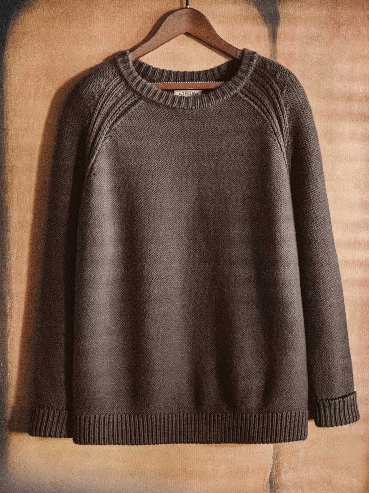 製品画像
ヘビーウェイト編みクルーネックセーター、コットンとアクリル混紡素材、16番手の糸で編まれた精緻なテクスチャー、ラグランスリーブデザインで動きやすさを強調、ヴィンテージ感を加えたオリジナルラベル付き

詳細画像
ヘビーウェイト編みのテクスチャー、コットン60.3%とアクリル39.7%の混紡素材、二重リブのネックライン、ラグランスリーブデザインによる快適な着心地、ヴィンテージ感とモダンを融合させたデザイン