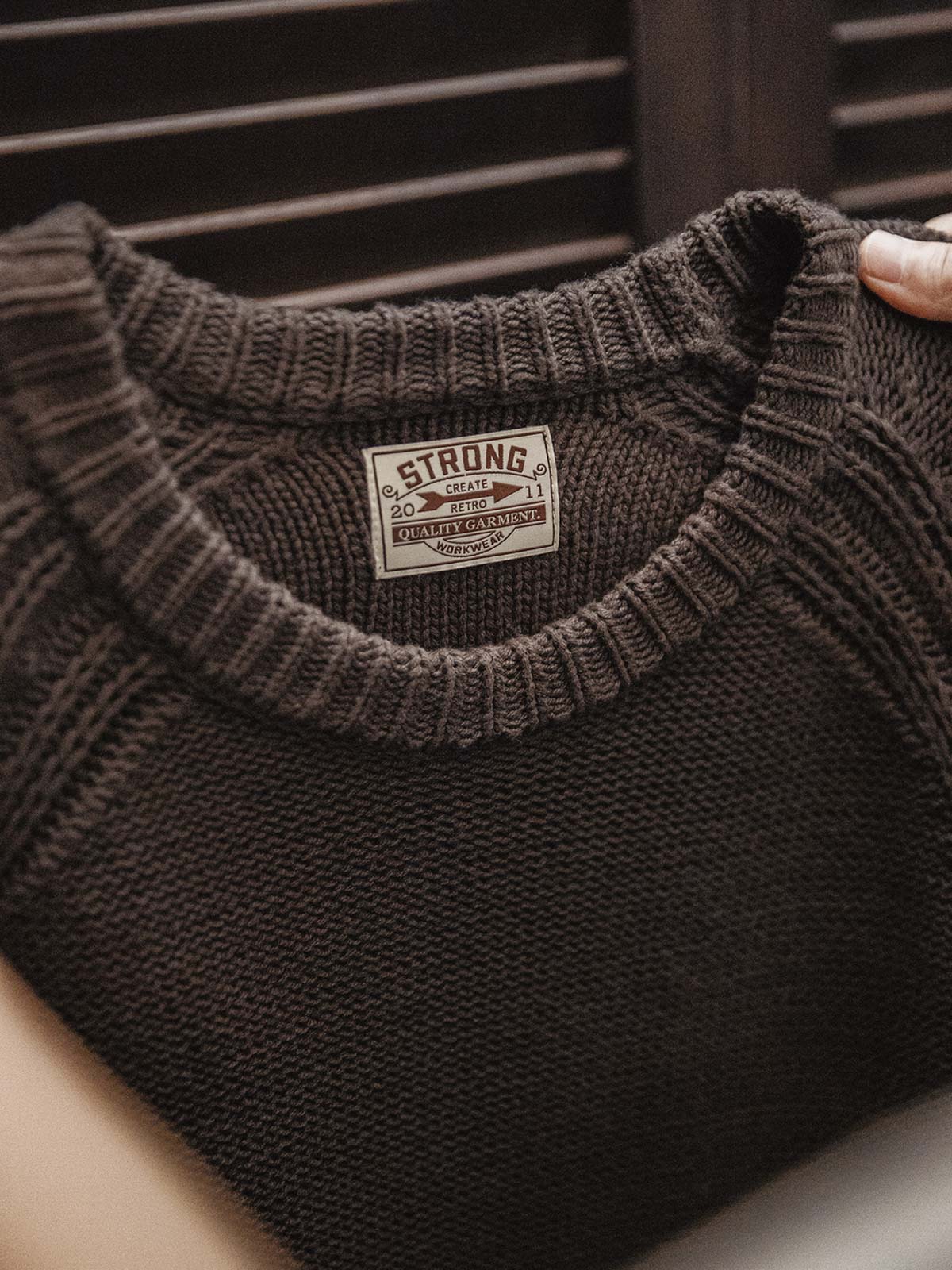 製品画像
ヘビーウェイト編みクルーネックセーター、コットンとアクリル混紡素材、16番手の糸で編まれた精緻なテクスチャー、ラグランスリーブデザインで動きやすさを強調、ヴィンテージ感を加えたオリジナルラベル付き

詳細画像
ヘビーウェイト編みのテクスチャー、コットン60.3%とアクリル39.7%の混紡素材、二重リブのネックライン、ラグランスリーブデザインによる快適な着心地、ヴィンテージ感とモダンを融合させたデザイン