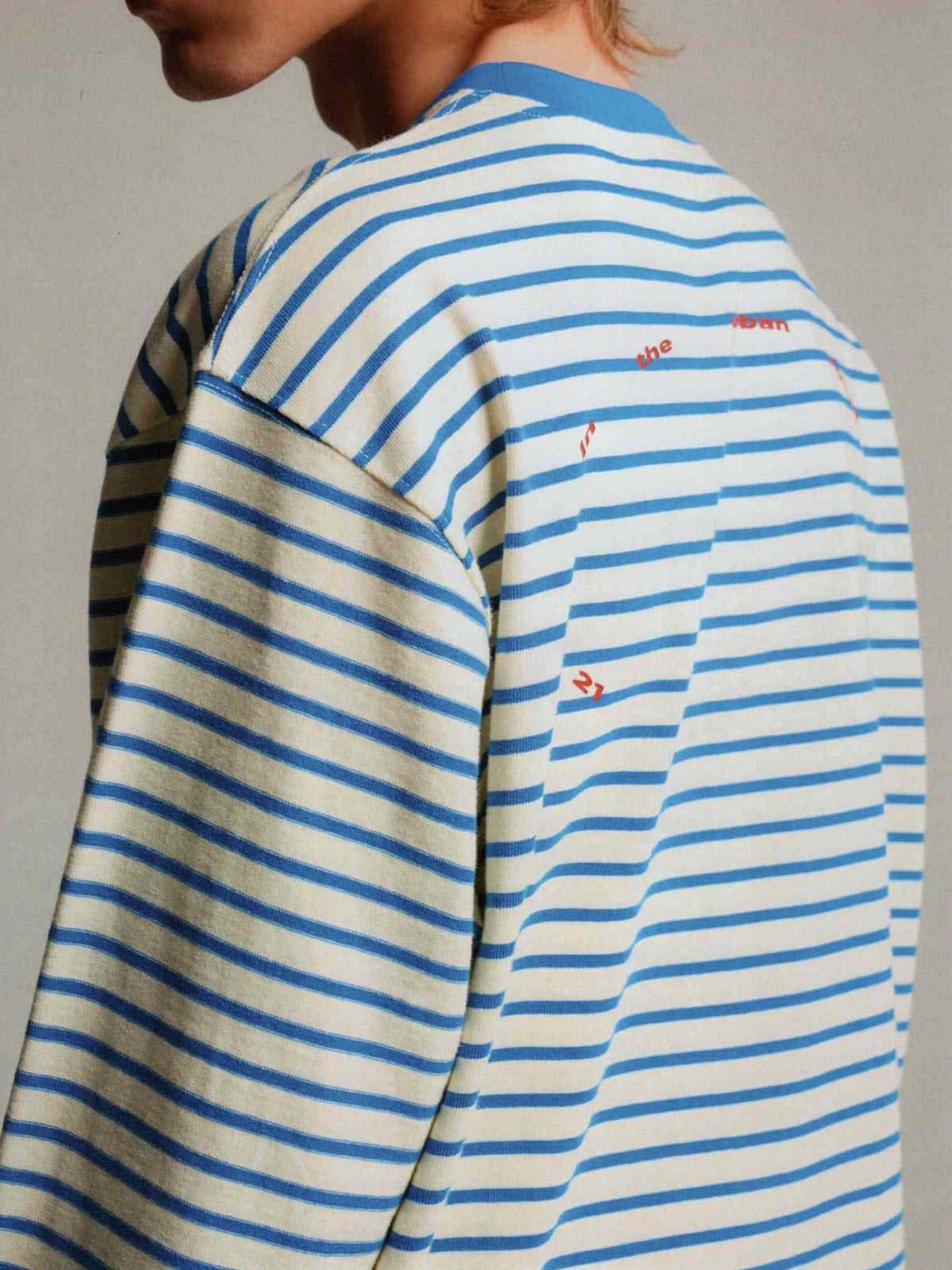 詳細画像: リブ切り替えストライプ長袖Tシャツのディテール図、刺繍風プリントとフェイクレイヤード効果を展示